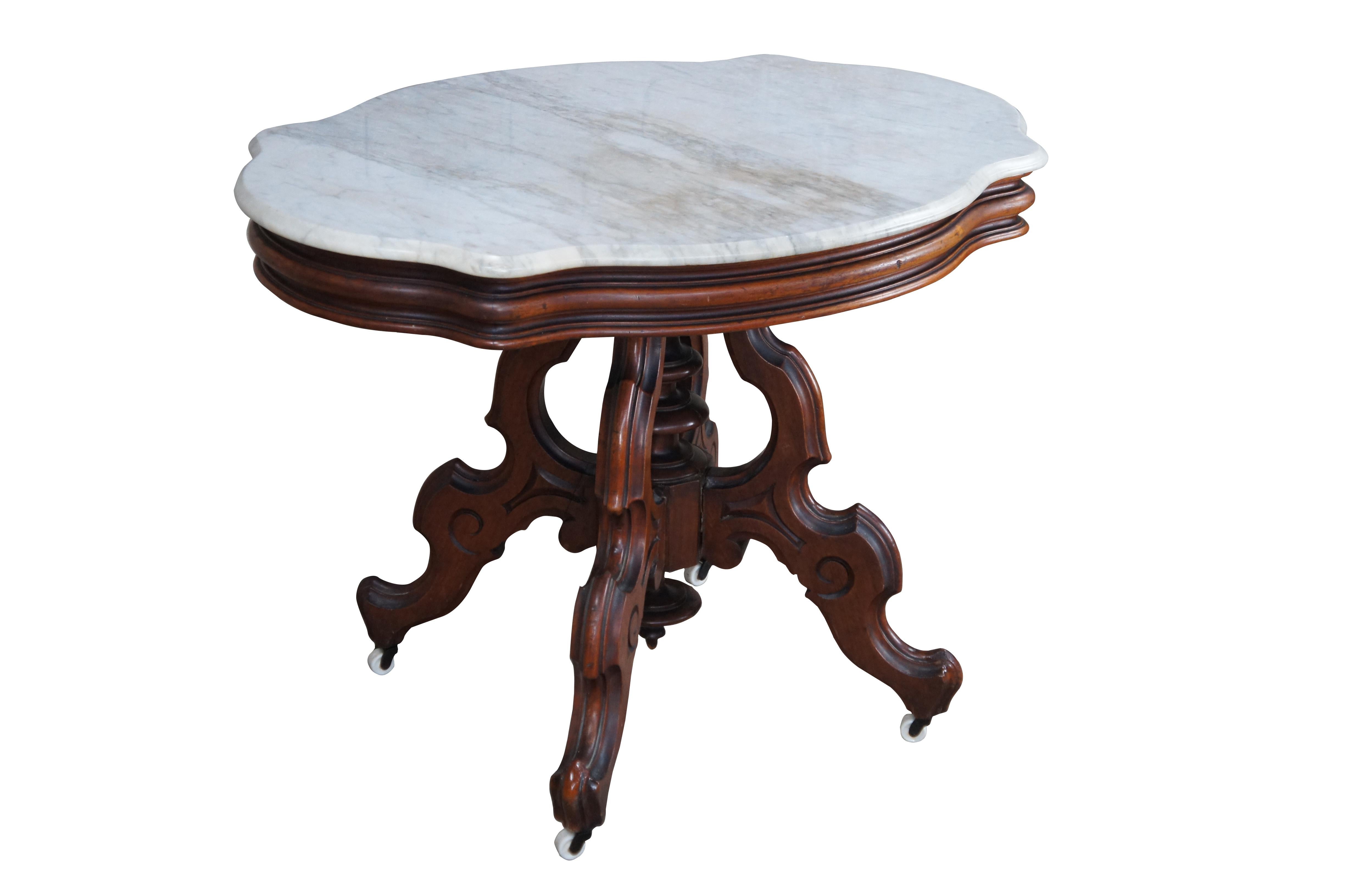 Antique 19th century Victorian Eastlake parlor table. Made from walnut featuring serpentine oval form with beveled marble top supported by turned center support with down finial and four serpentine carved legs over castors.

Dimensions:
38