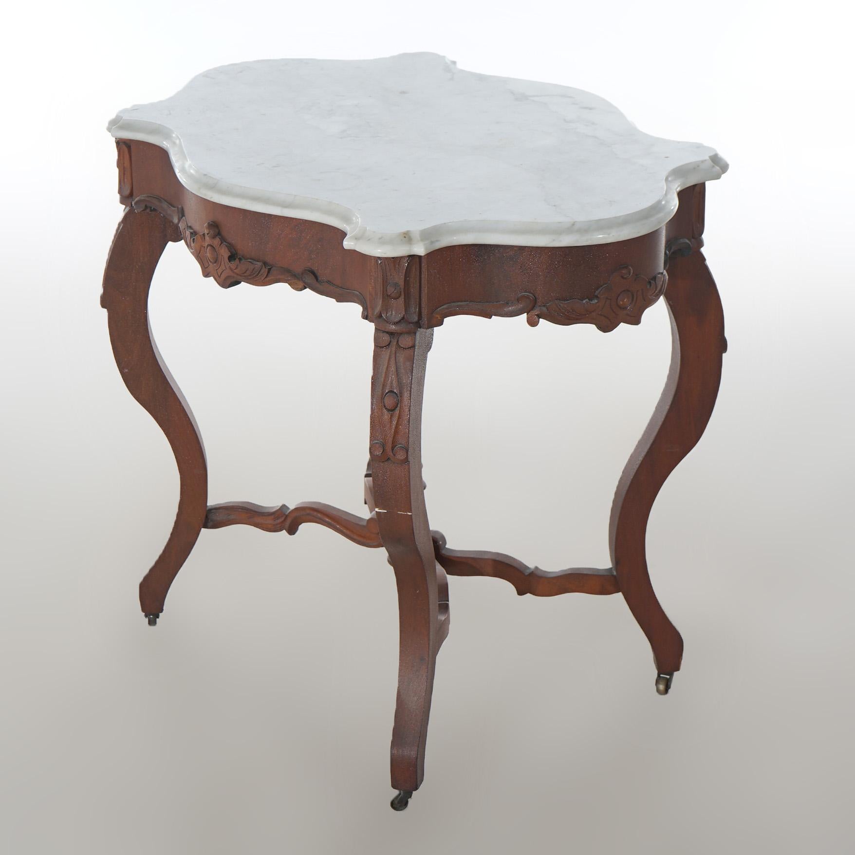 ***Ask About Discounted In-House Shipping***
An antique Victorian parlor table offers shaped and beveled marble turtle top over carved walnut base having floral accents and raised on cabriole legs with central urn form finial on stretcher,