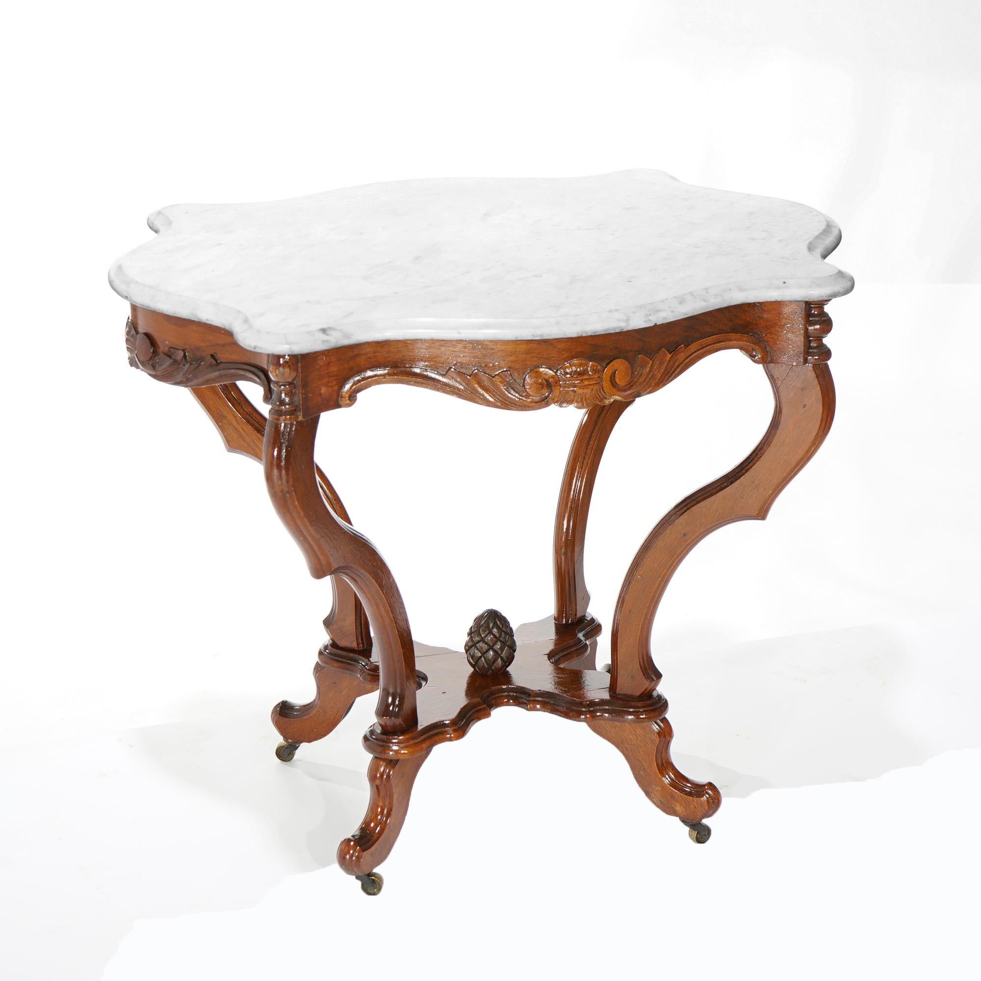 An antique Victorian parlor table offers shaped marble turtle top over carved walnut base having shaped skirt with carved scroll and foliate elements, raised on scroll form cabriole legs with central pineapple finial, c1890.

Measures- 28.75''H x