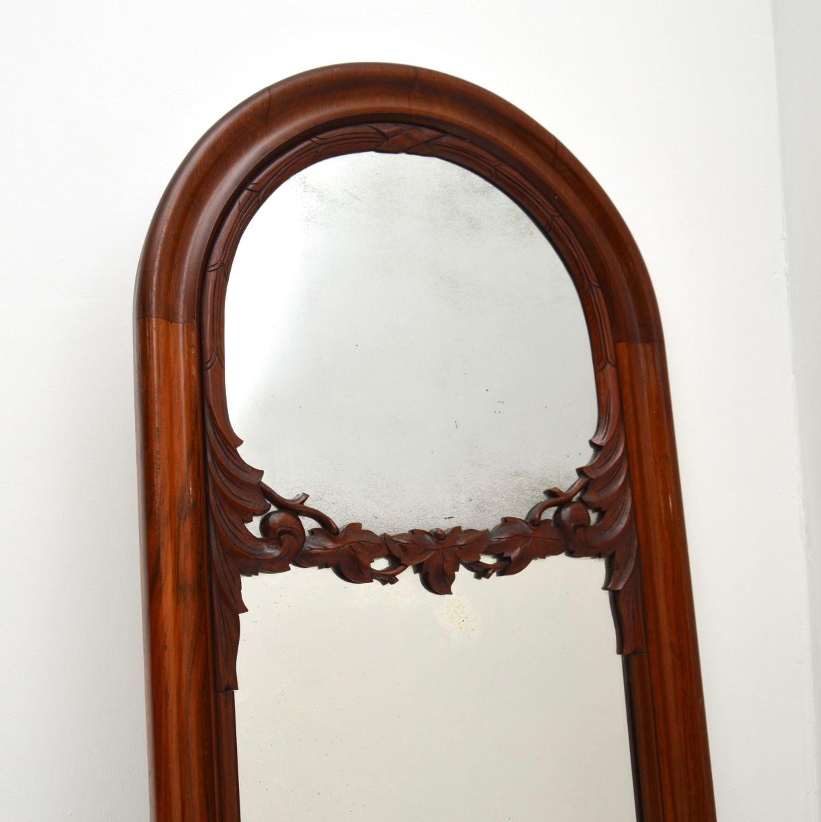 A beautiful antique Victorian carved walnut mirror, made in England and dating from around the 1850-1870 period.

It is of outstanding quality and has a lovely, tall design. The solid walnut frame has a gorgeous colour tone and patina, there is