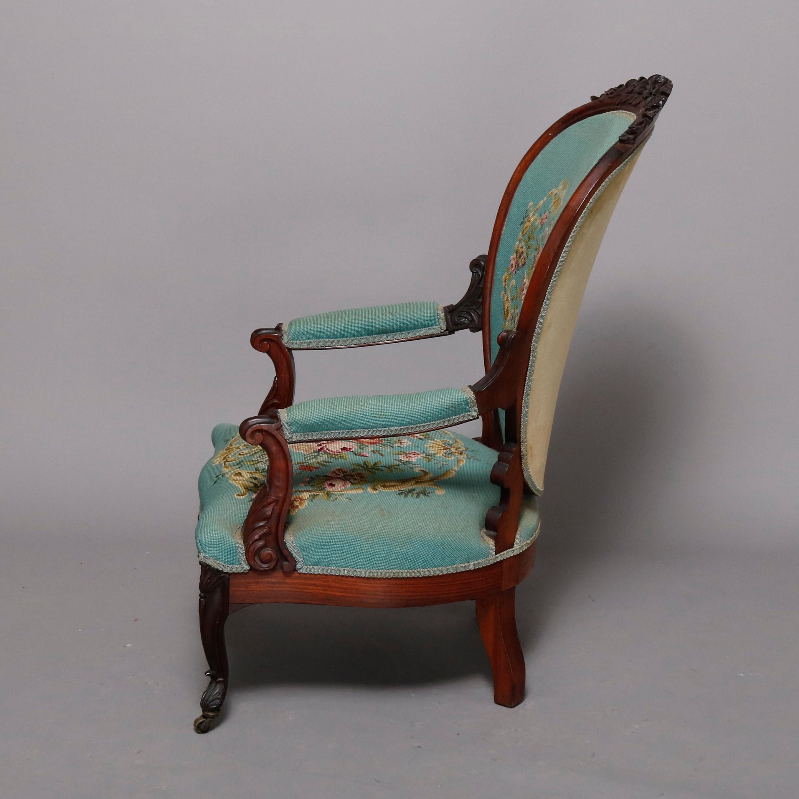 An antique Victorian parlor armchair offers walnut frame with carved floral and foliate crest surmounting medallion back with floral needlepoint upholstery, covered arms and matching seat, raised on cabriole legs, circa 1880

Measures: 40.5