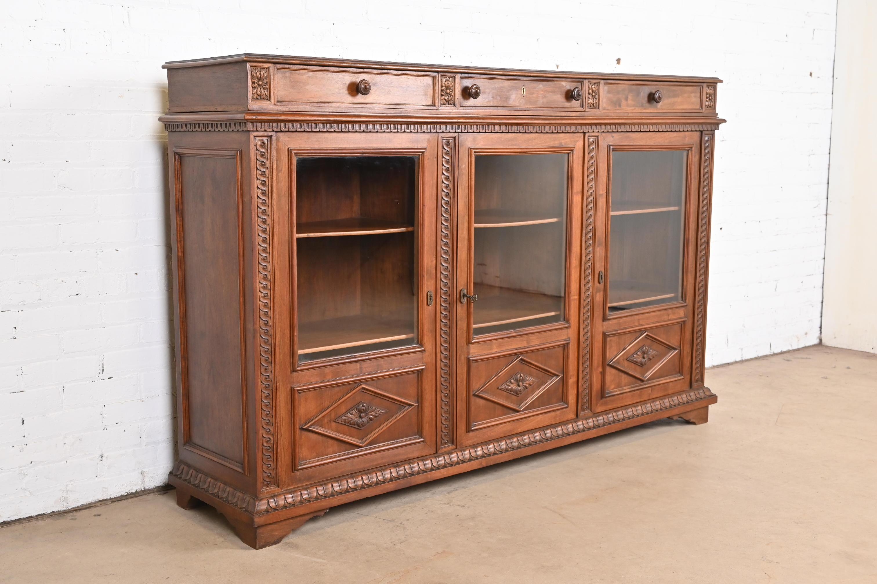 An outstanding antique Victorian or Renaissance Revival triple bookcase cabinet

In the manner of R.J. Horner

USA, Circa 1890s

Carved walnut, with glass front doors and brass hardware. Key is included.

Measures: 71.5