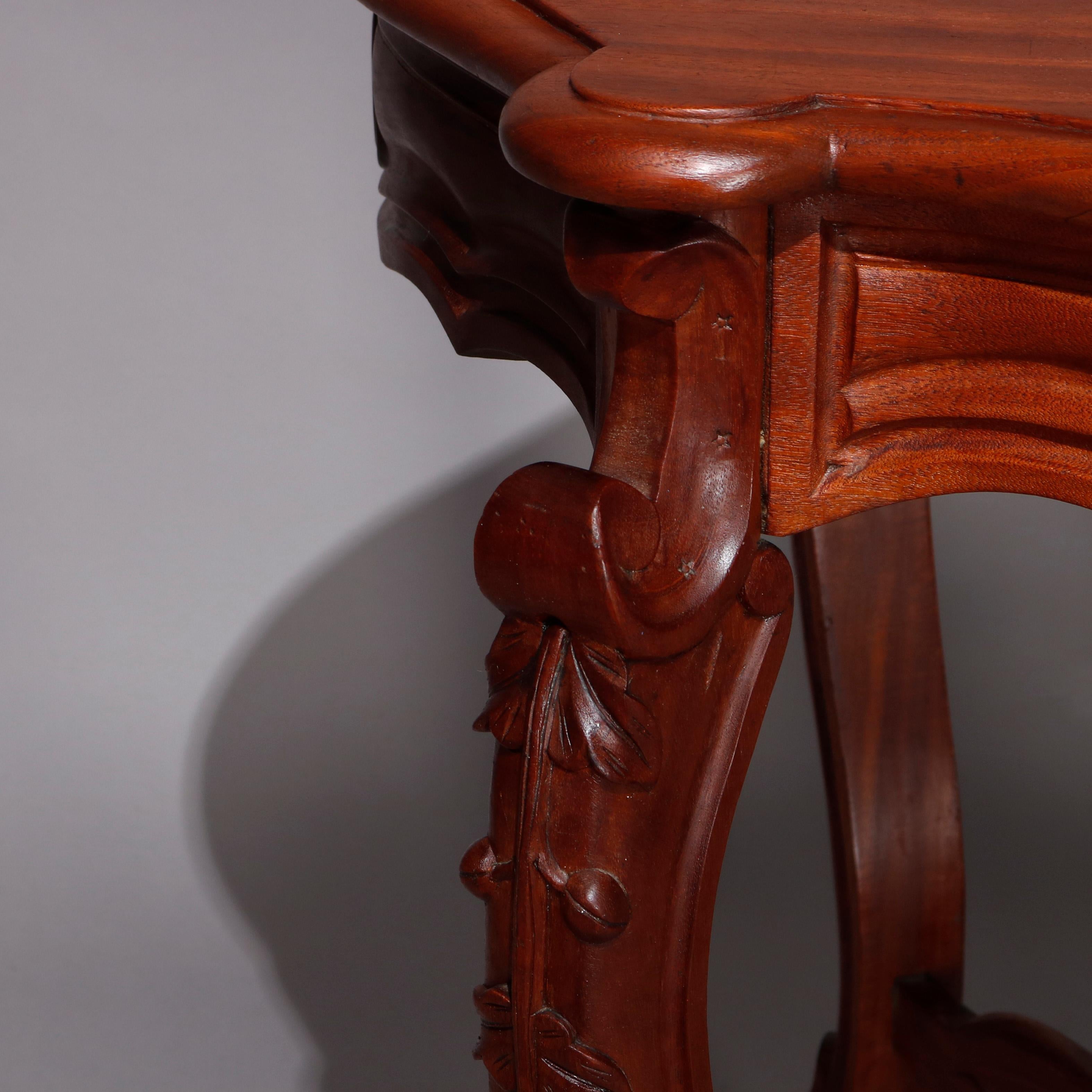 An antique Victorian turtle top table offers carved walnut construction with shaped top surmounting skirt with central medallion, raised on cabriole legs with carved acanthus knees and feet, scroll form X-stretcher with central turned finial, circa