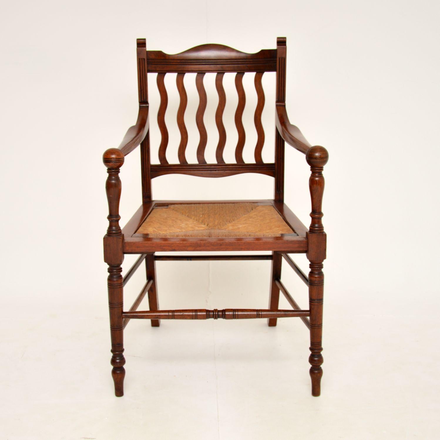 A beautiful and elegant antique Victorian Arts & Crafts armchair / desk chair. This was made in England, it dates from around the 1880-90’s period.

It has a beautiful design, with an amazing frame and drop in rush seat. The backs slats have an