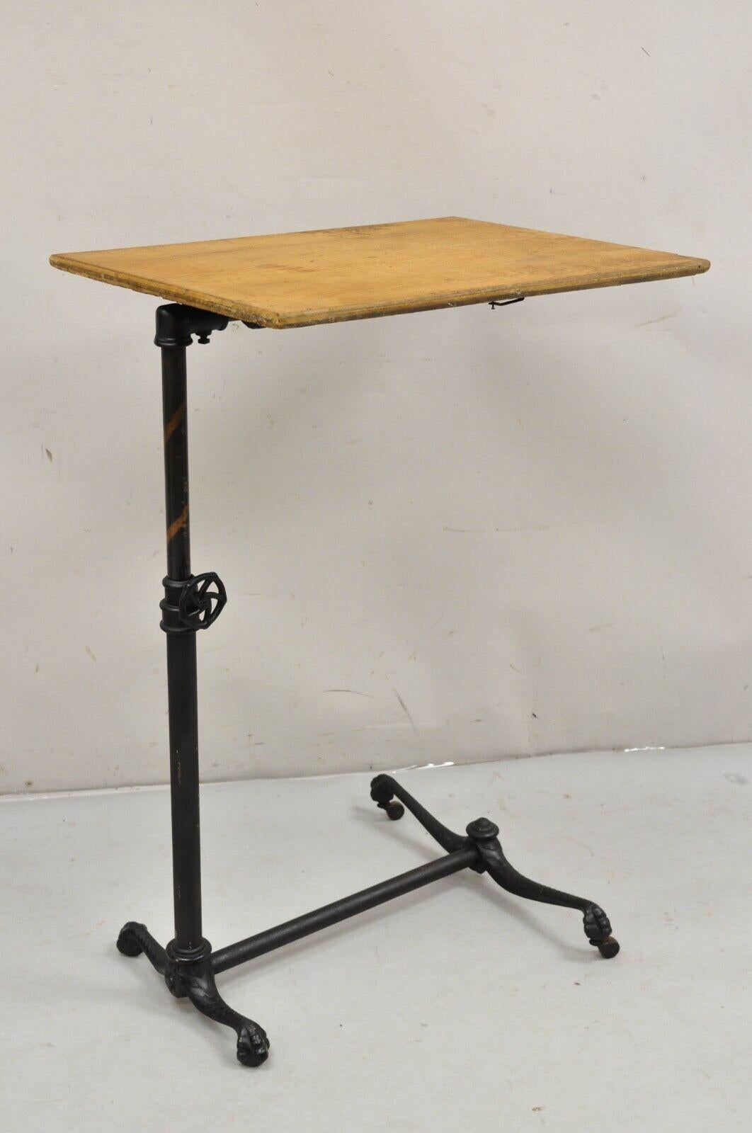 Antique Victorian Cast Iron Adjustable Small Surgical Drafting Table w/ Oak Top. Item featured is a nice small size, cast iron base with paw feet on rolling casters, adjustable height with iron knob, tilting top with very unique spring and toothed