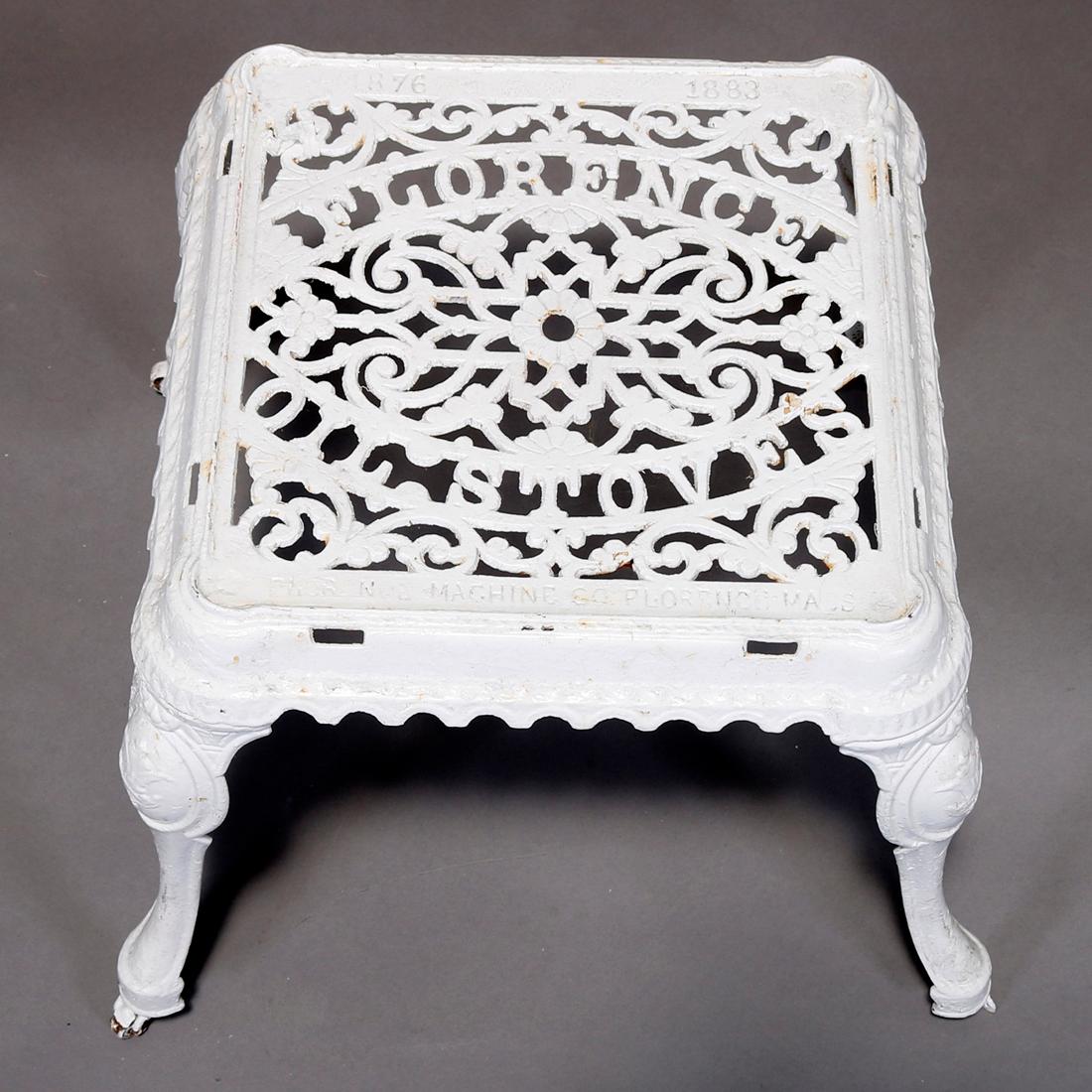 An antique Victorian advertising stand offers cast iron construction with pierced foliated filigree top having 