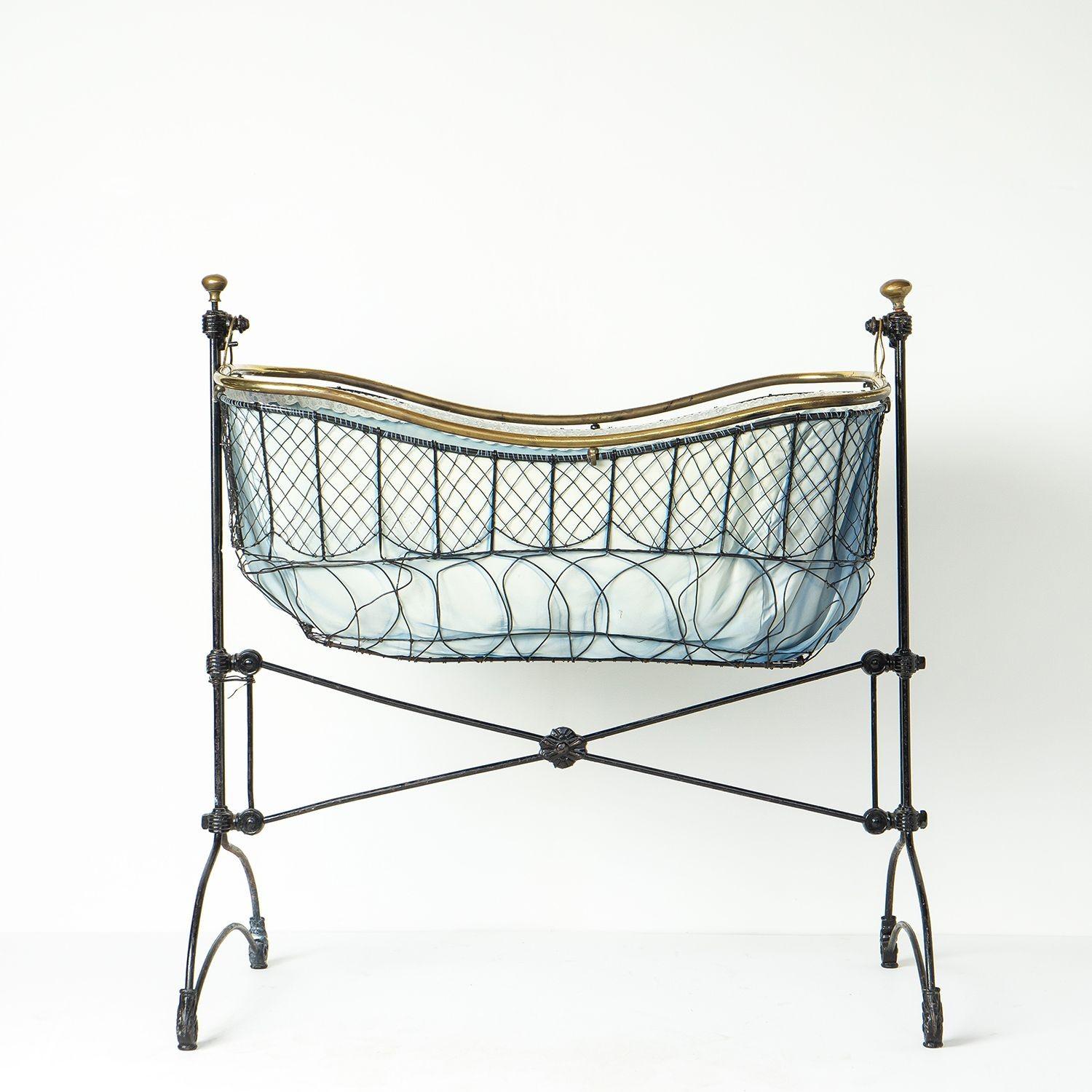 Antique Wire Work Moses Basket Crib

The Rolls Royce of Victorian cradles.

Cast and wrought iron frame with wire work cradle.

Brass rim and knob finials.

Easy rocking action.

Original blue cotton and white lace fitted interior.

It is in good
