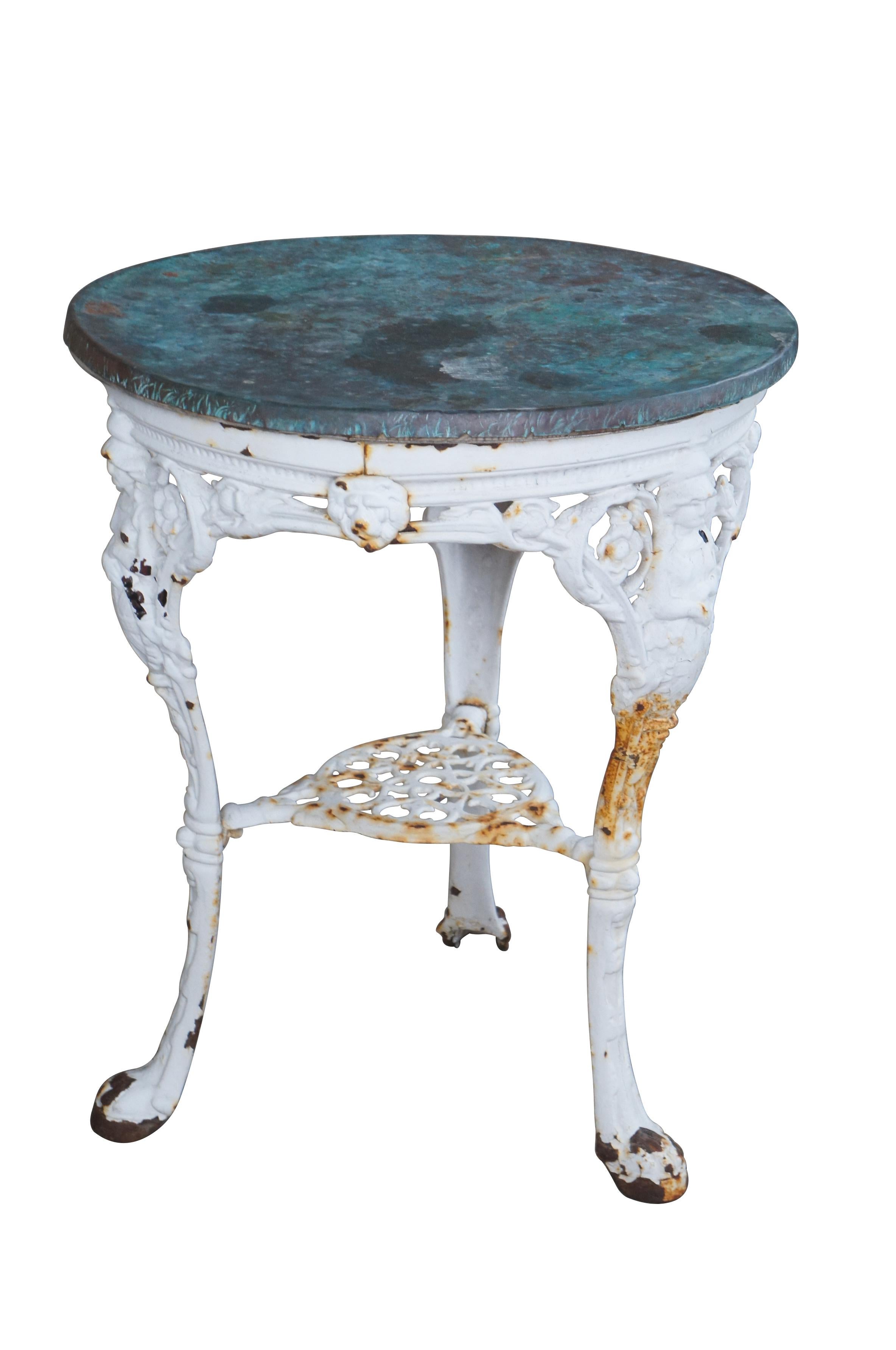 Antiker viktorianischer Gartentisch mit schwerem Gusseisensockel mit netzartigem Blumen-/Löwenkopf-/Figurenmotiv und runder kupferverkleideter Platte.  Auf den drei oberen Beinen ist eine figurale 