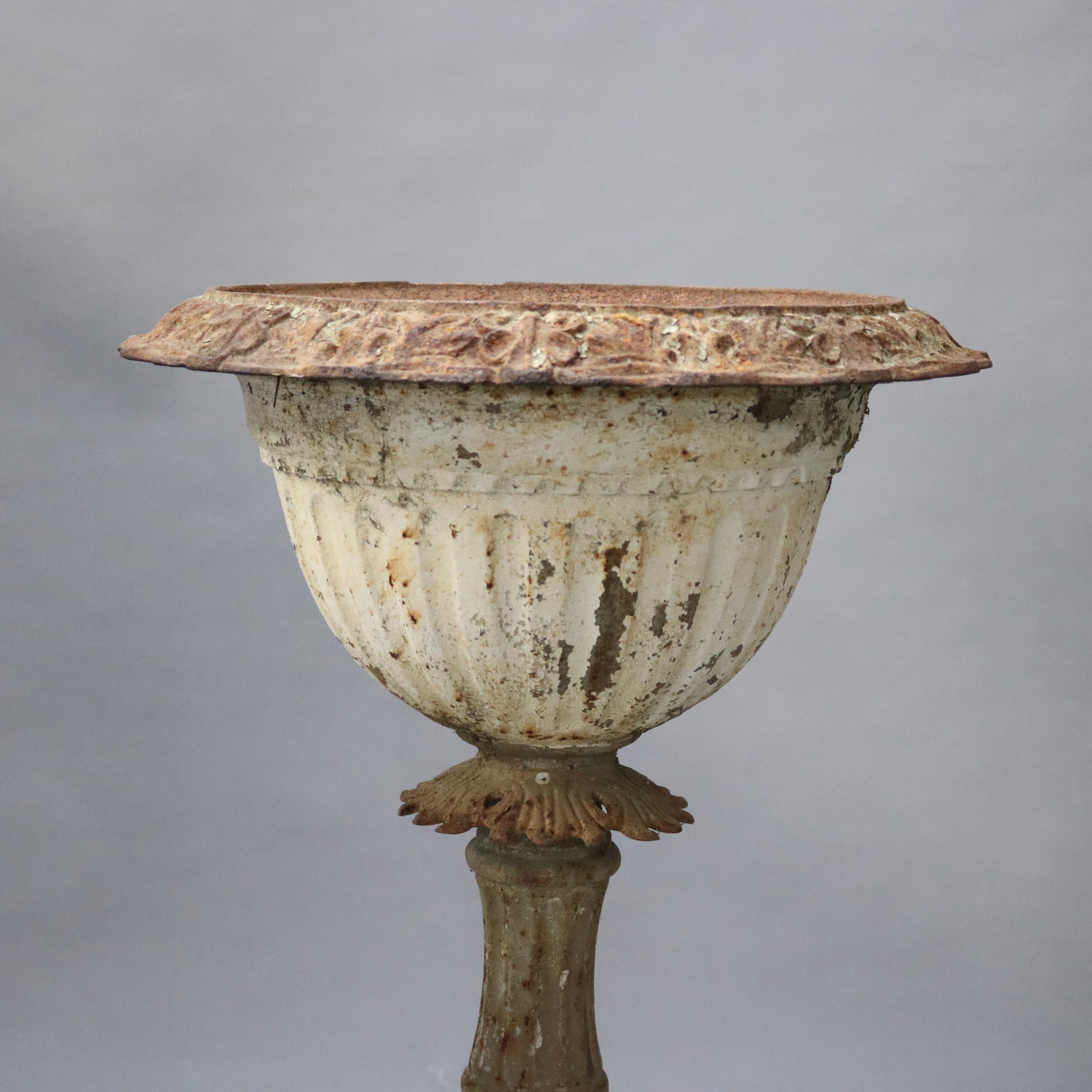 An antique Victorian Mott School garden planter offers painted cast iron construction with urn form jardinière surmounting shaped pedestal having foliate collar and raised on flared embossed base, circa 1890

Measures: 36.5