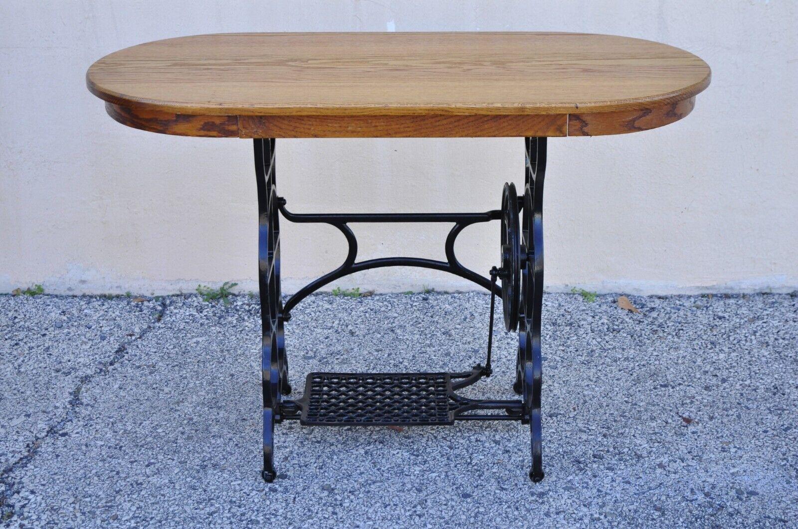 Antique Victorian cast iron treadle sewing machine base side table oval oak top. Item features an oval oak wood top, working cast iron treadle sewing machine base, very nice antique item, great style and form. Circa Early 1900s. Measurements: 30