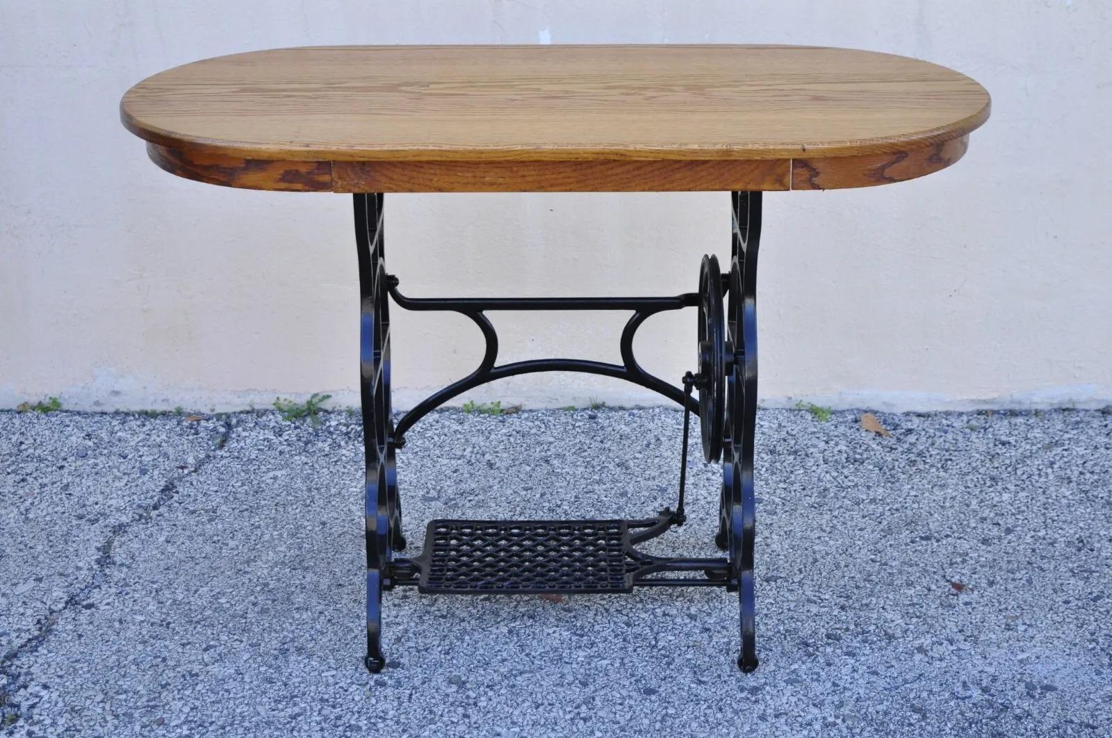 Antique Victorian cast iron treadle sewing machine base side table oval oak top. Item features an oval oak wood top, working cast iron treadle sewing machine base, very nice antique item, great style and form. Circa Early 1900s. Measurements: 30