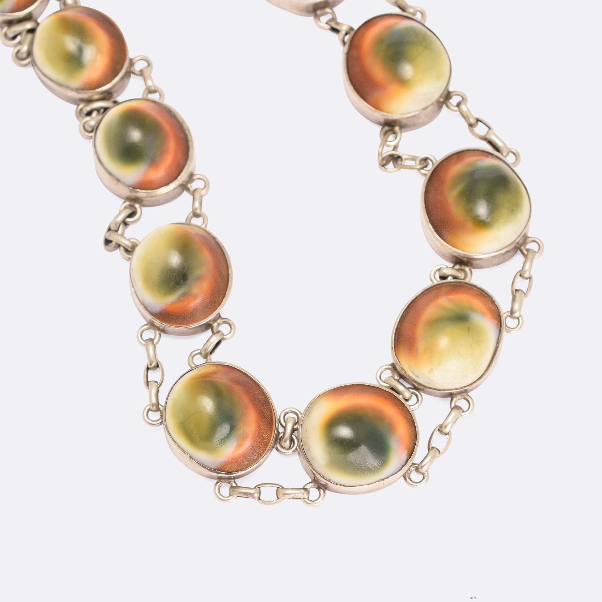 An unusual antique riviere necklace set with 15 operculum stones. These curious 'gemstones' (commonly known as cat's eye or shiva's eye) arean anatomical part of the marine snail; operculum literally means 