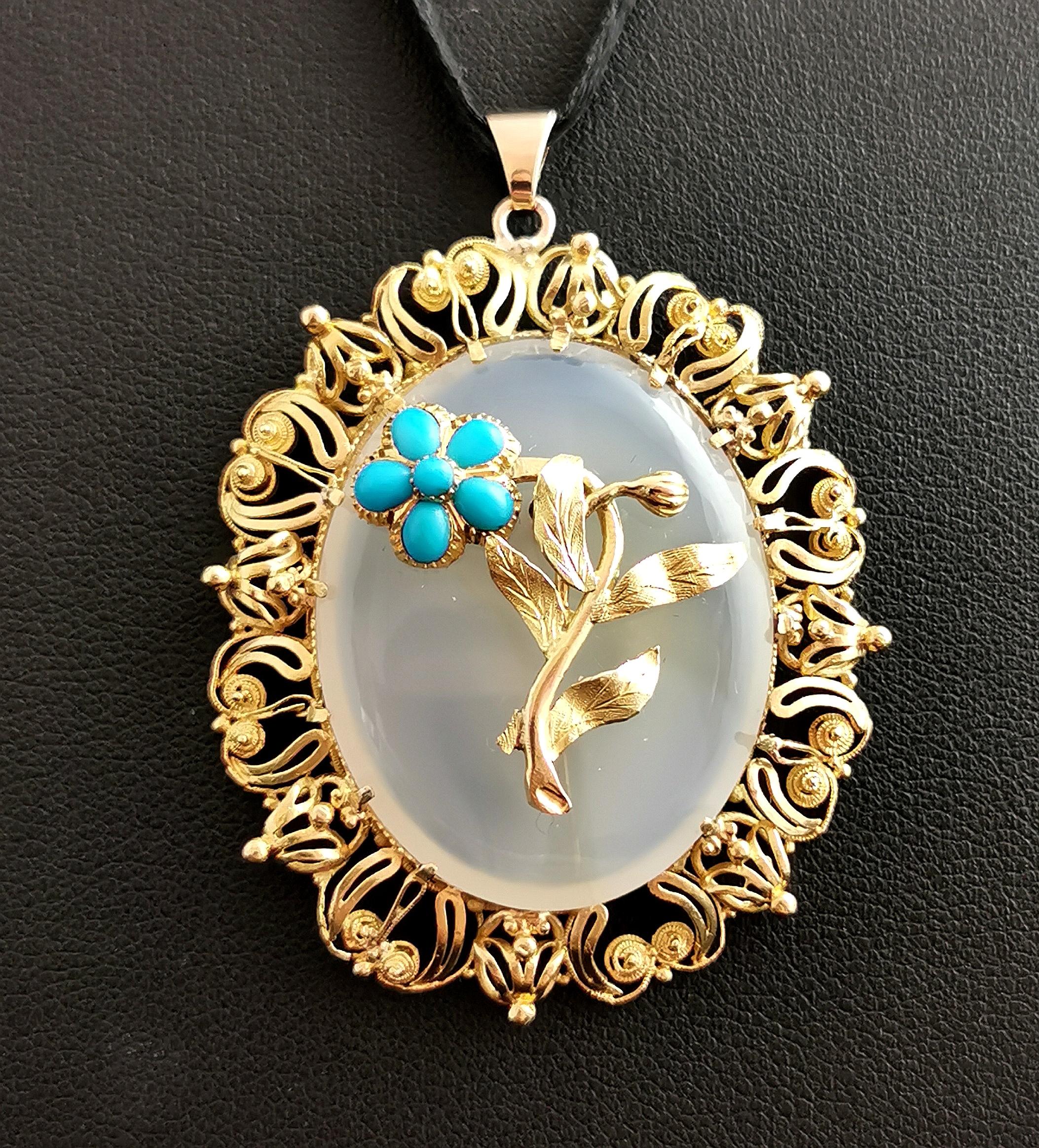 A beautiful antique Victorian era chalcedony and turquoise pendant.

It is an oval shaped pendant, the cool white chalcedony claw mounted into an elaborate 18kt yellow gold frame with wirework and scroll work.

The chalcedony has a pretty yellow