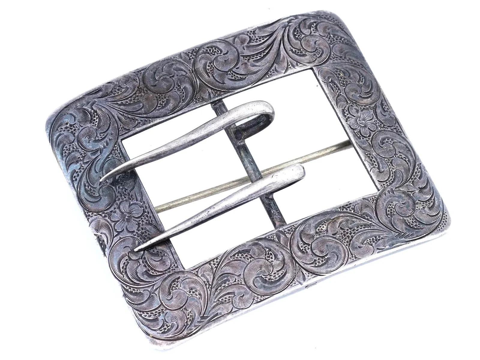 Un'antica fibbia da cintura in argento sterling americano della fine del XIX o dell'inizio del XX secolo. Forma rettangolare, elaborato decoro ornamentale inciso. Marchio Sterling sul retro. Peso totale: 40 grammi. Argenteria da collezione, gioielli