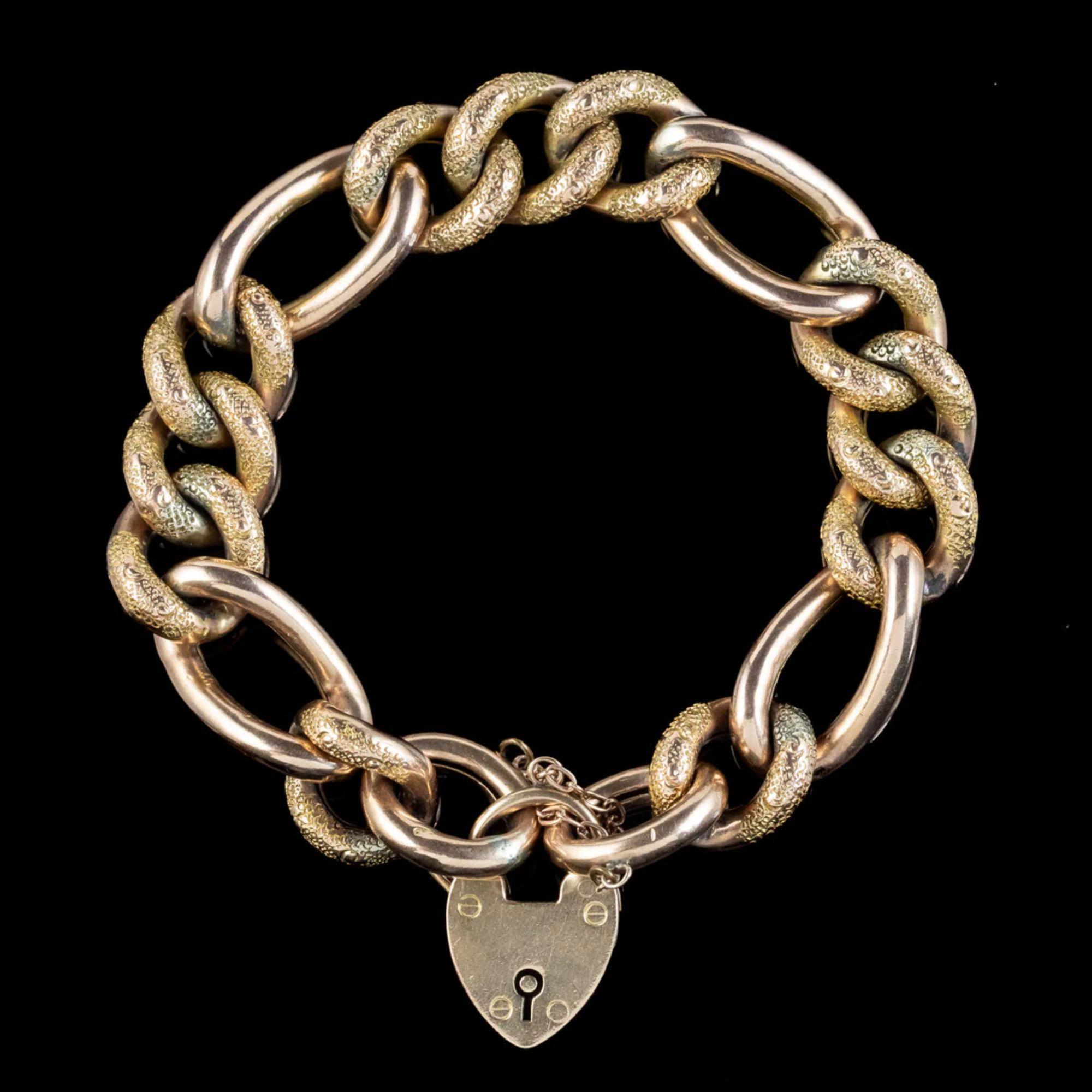 A grand antique Victorian curb bracelet made up of chunky 9ct gold links that have developed a lovely golden-bronze patina with age. The smallest links have been engraved with textured patterning across the top and contrast beautifully against four