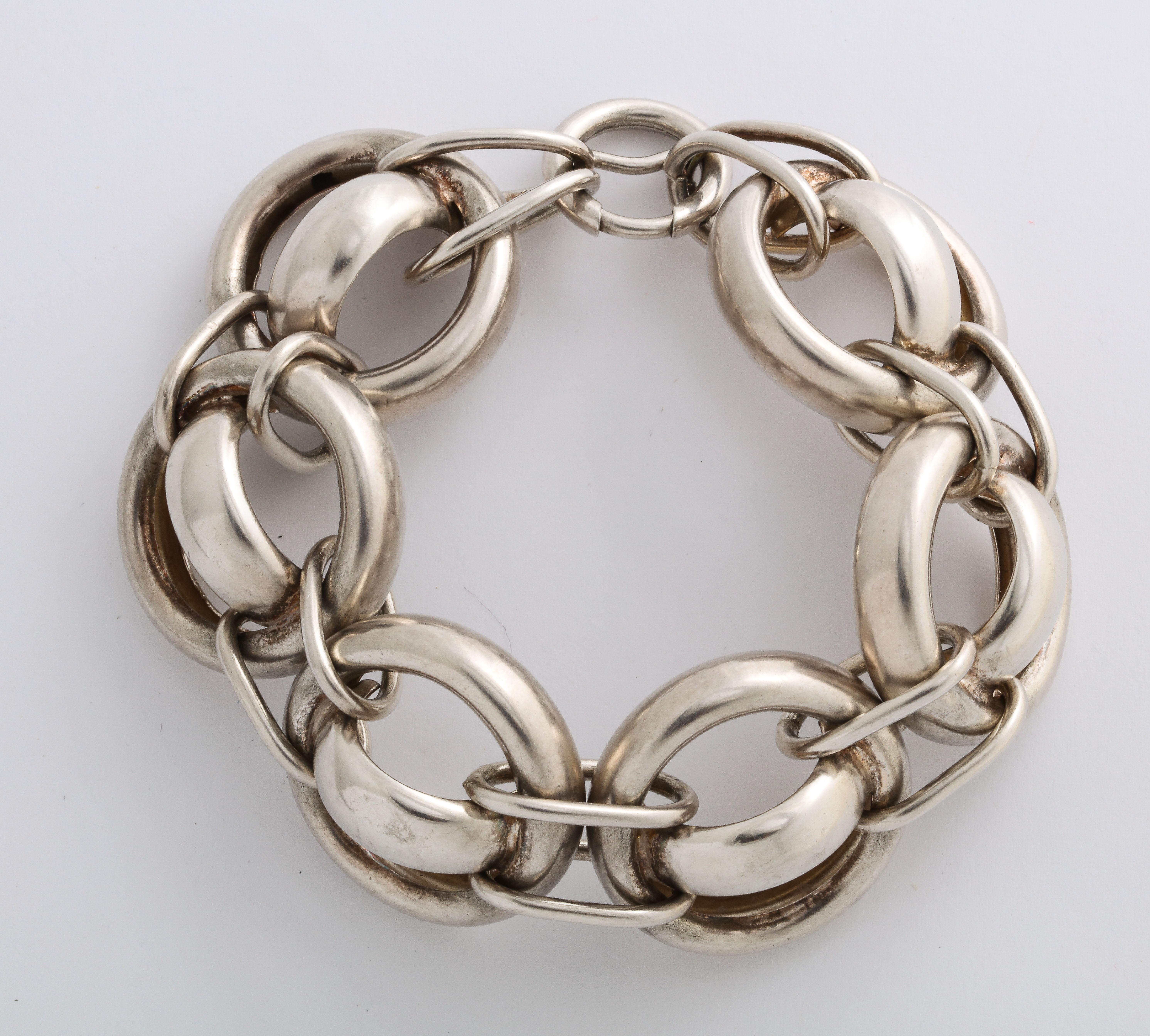 Unusually large for a Vintage mid century bracelet, bold, and chunky, this silver bracelet is as stunning as it is fun. The links are round with a horizontal curved link in the center. Each inch large circle is connected by two horizontal links to