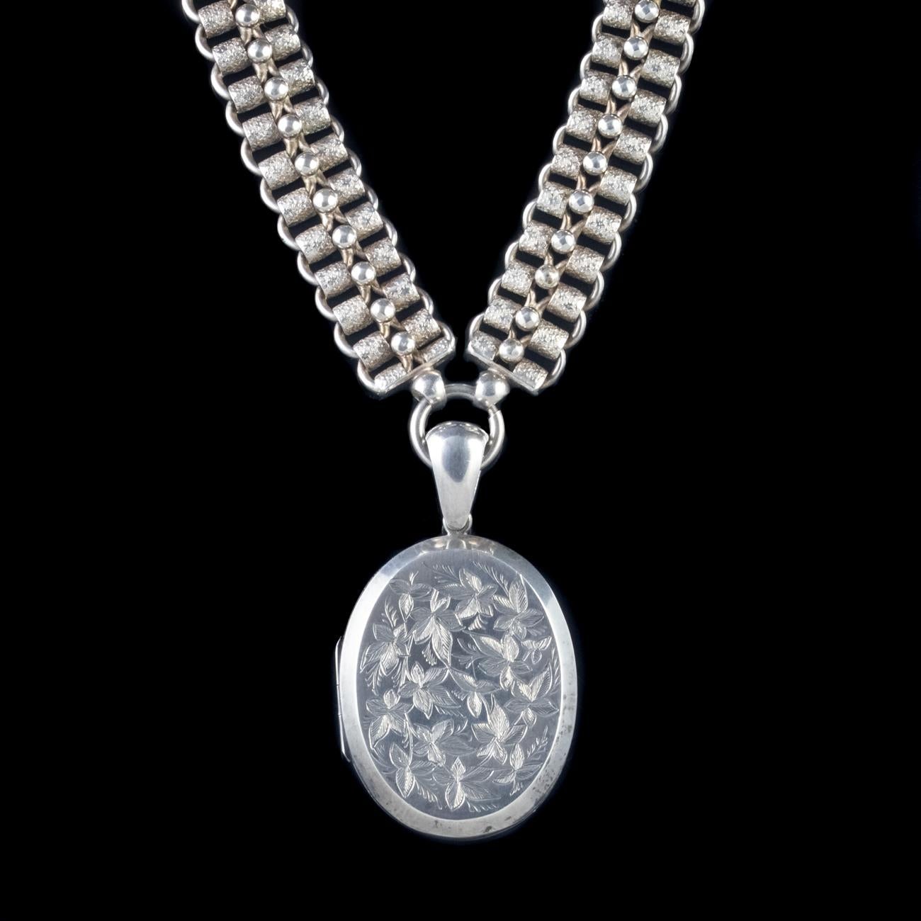 This magnificent Antique Victorian collar and locket has been commissioned in Sterling Silver and is dated 1882. The locket features engravings of ivy on the front and opens up to reveal two windows complete with rims that can be used to house
