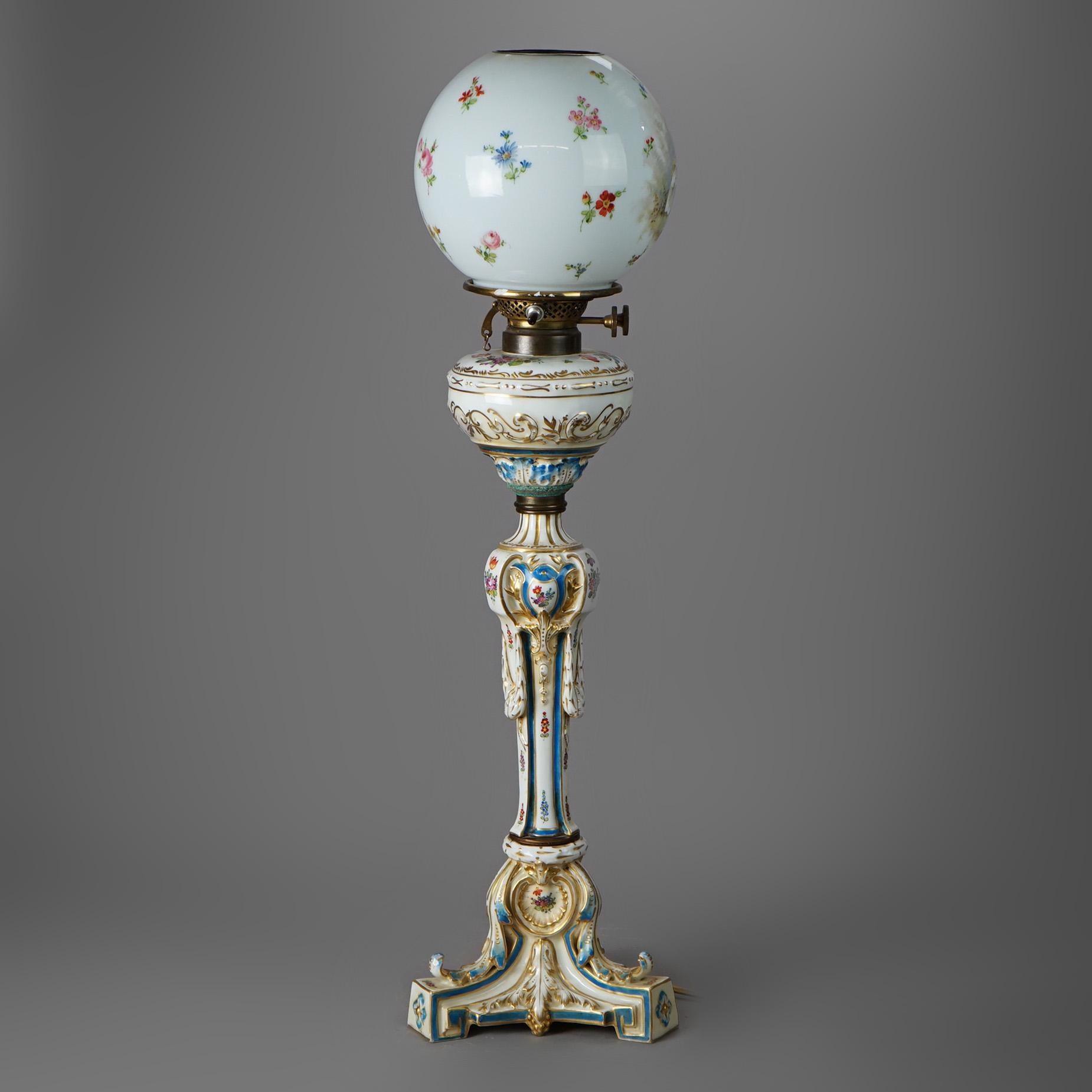 An antique Victorian Continental banquet lamp offers floral glass globe over porcelain base having hand painted flowers and gilt highlights, electrified, 19th century

Measures - 28.5