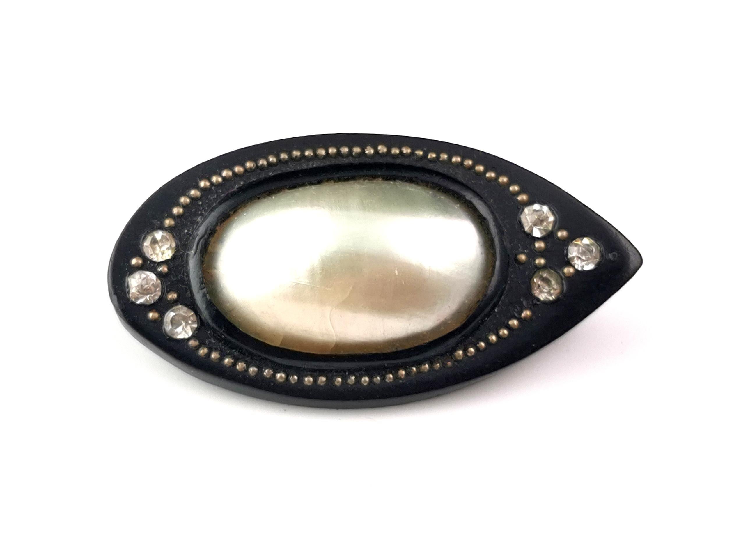 A rare and unusual find is this antique Victorian era Whitby Jet and Coque de Perle eye brooch.

Coque de Perle jewellery was very popular in the Georgian era, a faux pearl, usually large in size, created using Indian nautilus shells or pearly