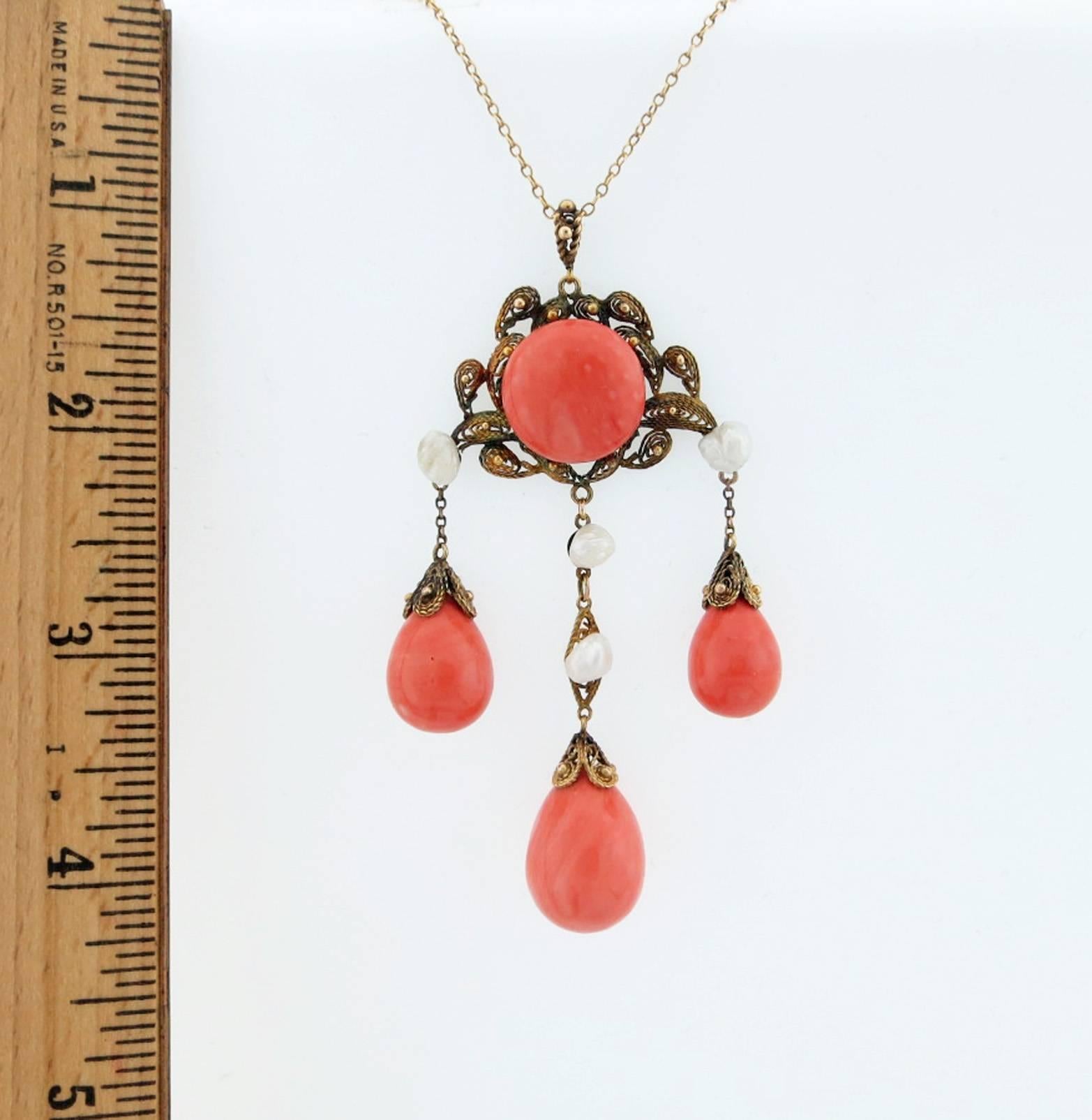 Articulated natural coral pendant with fresh water pearl accents in 14kt. yellow gold granulated wire work mount. The chain is 18 inches in length with a  3 1/2 inch pendant that is set with a coral button center measuring approx 16.8mm. the center