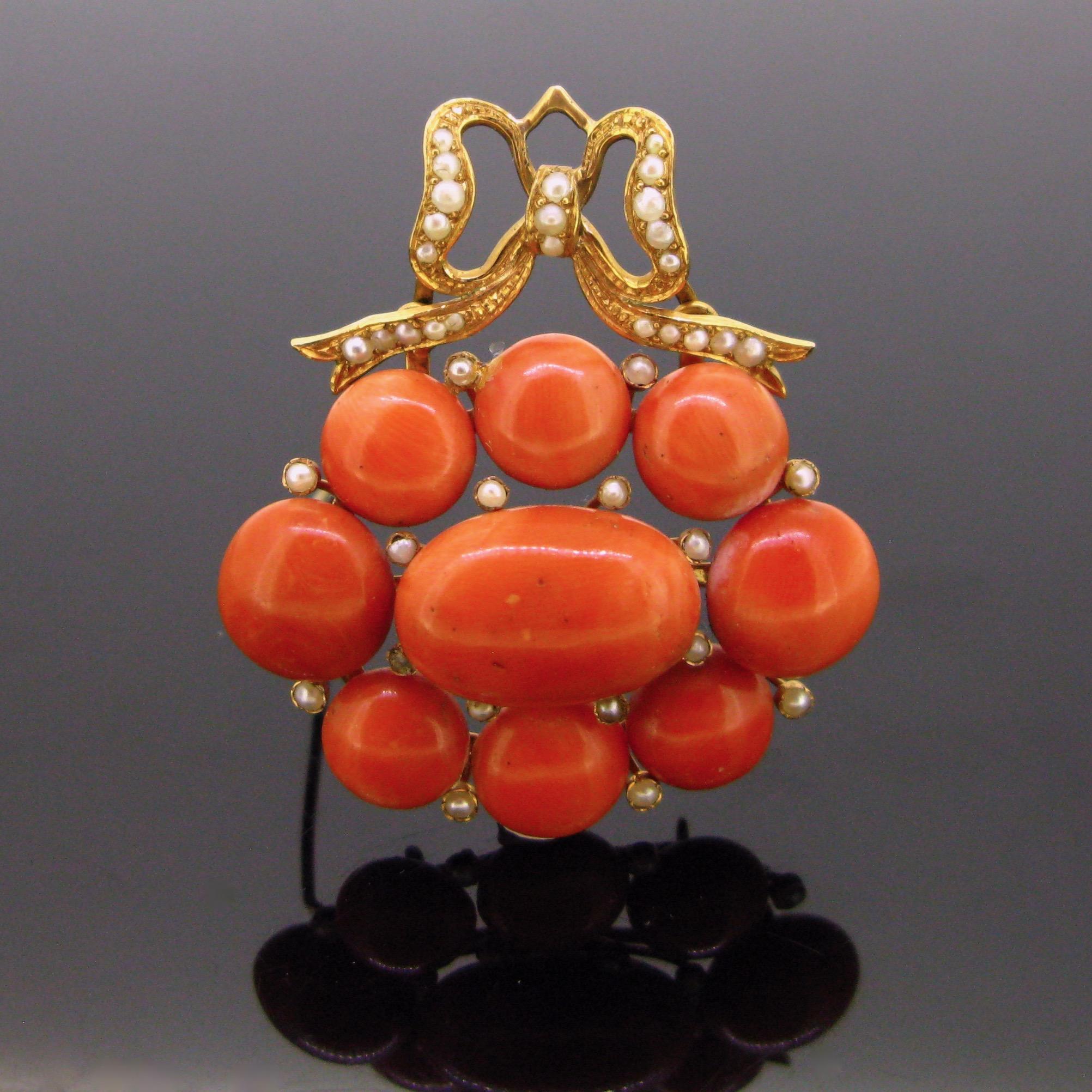 This brooch is ravishing. It is adorned with 8 beads of natural corals enhanced with seed pearls. The top of the brooch is nicely adorned with a bow also set with seed pearls. The mount is fully made in 18kt yellow gold. It could be worn as a