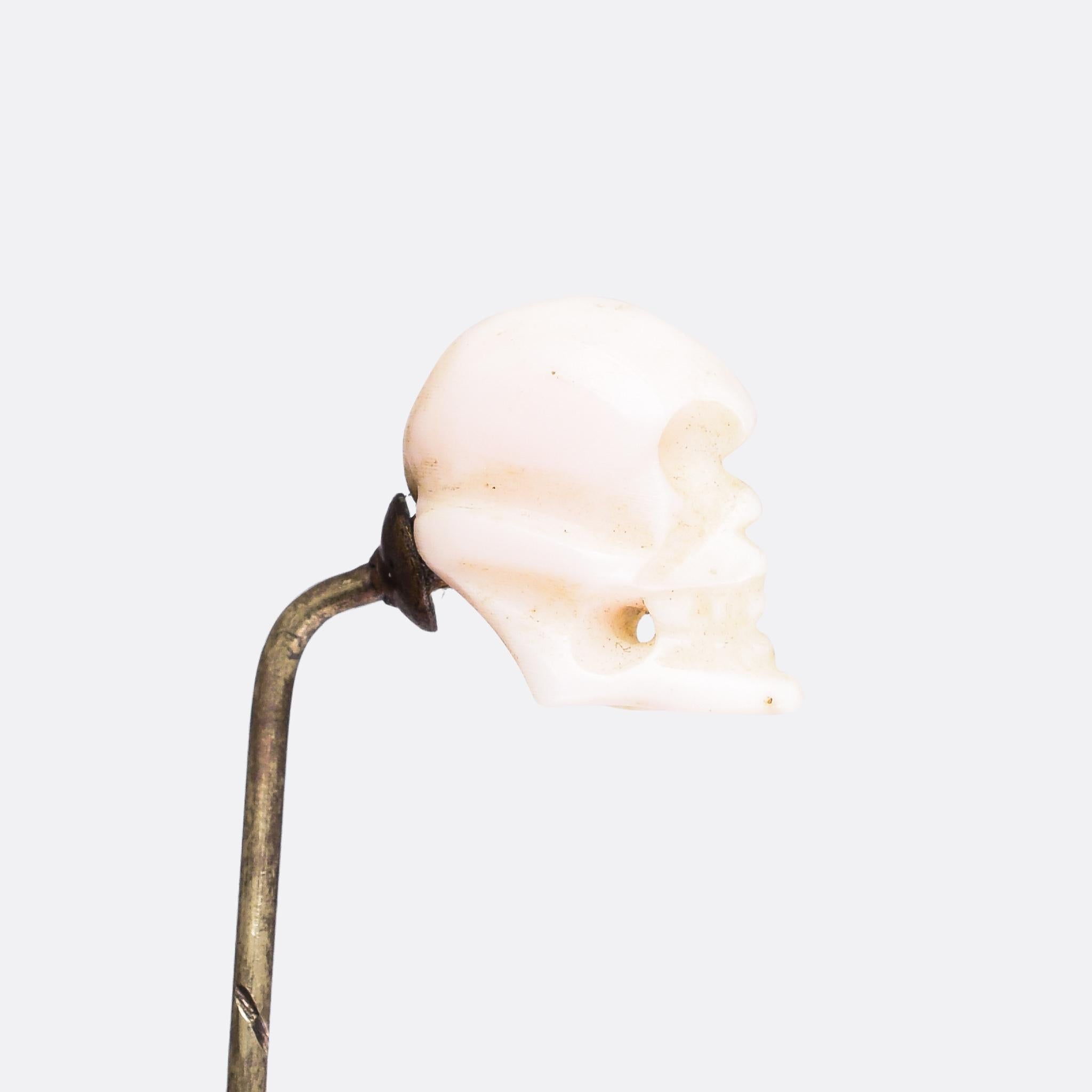 A cool antique stick pin featuring a carved coral skull. It dates from the Victorian era, circa 1880, and remains in excellent condition. The features of the skull are ever-so-slightly exaggerated, giving it an almost cartoon-like