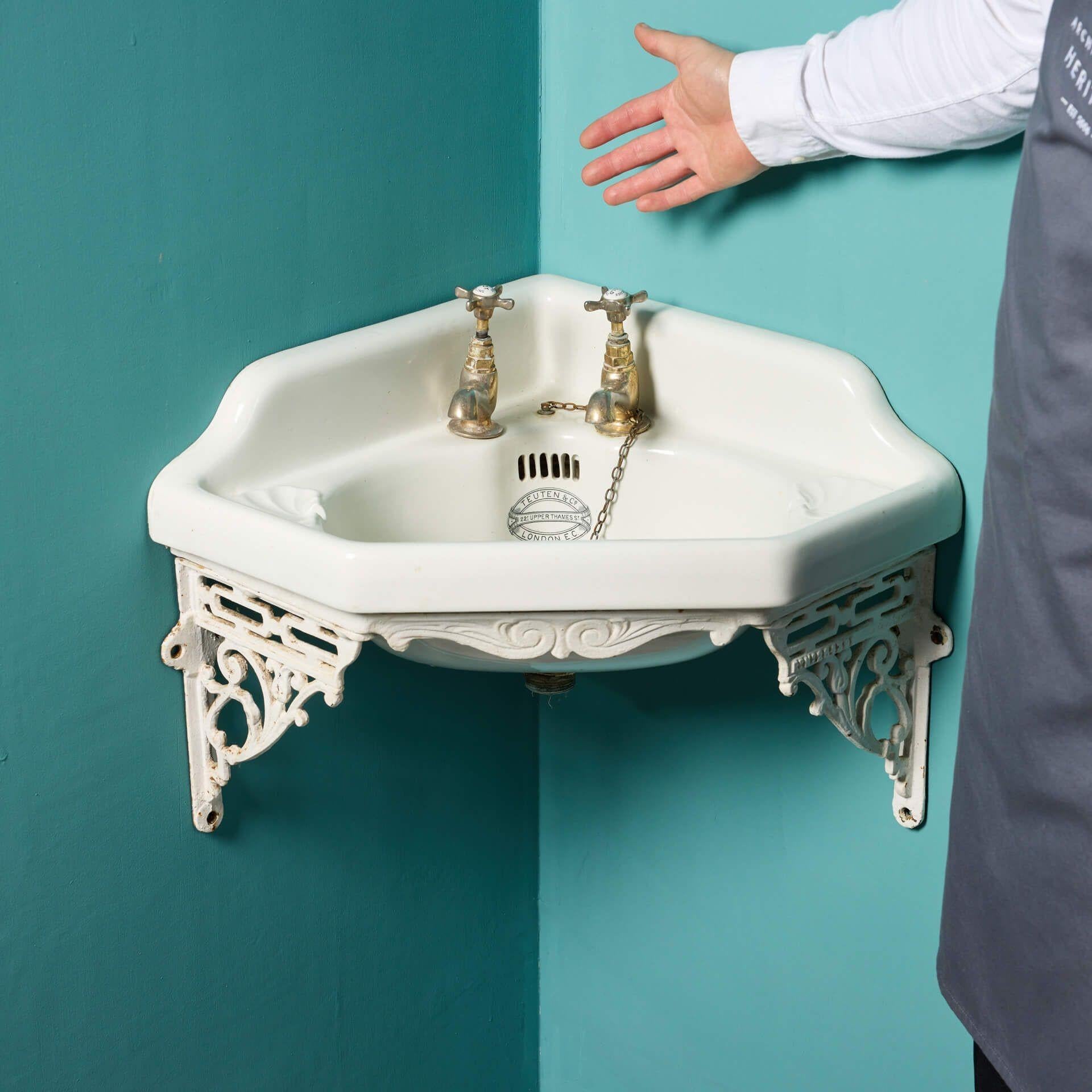An antique Victorian corner sink with a wall bracket stamped 