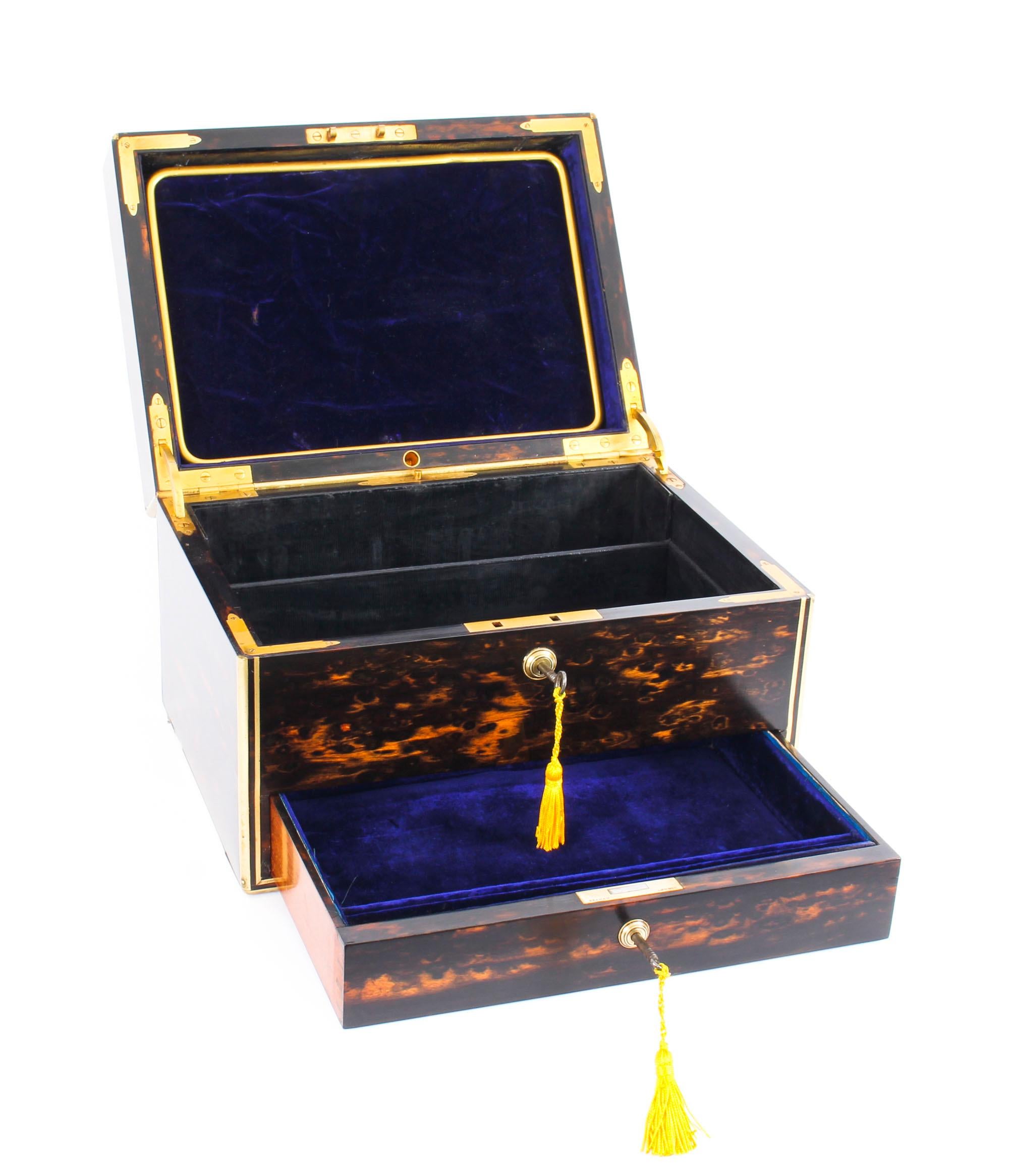 This is an exceptional high-quality antique English Victorian coromandel and brass banded jewellery box and dressing casket by the renowned manufacturers of boxes and caskets, Jenner & Knewstub of London, and dated March 1873. 

This splendid