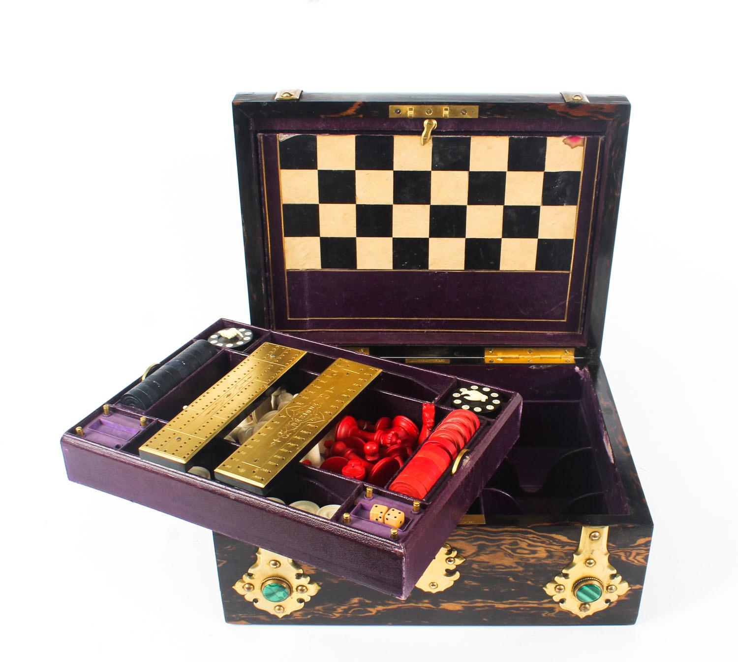 This is a wonderful antique Victorian coromandel and brass bound games compendium, the cut brass applied with six beautiful malachite bosses, Circa 1860 in date.

Bearing the engraved brass label of the world renowned retailer 