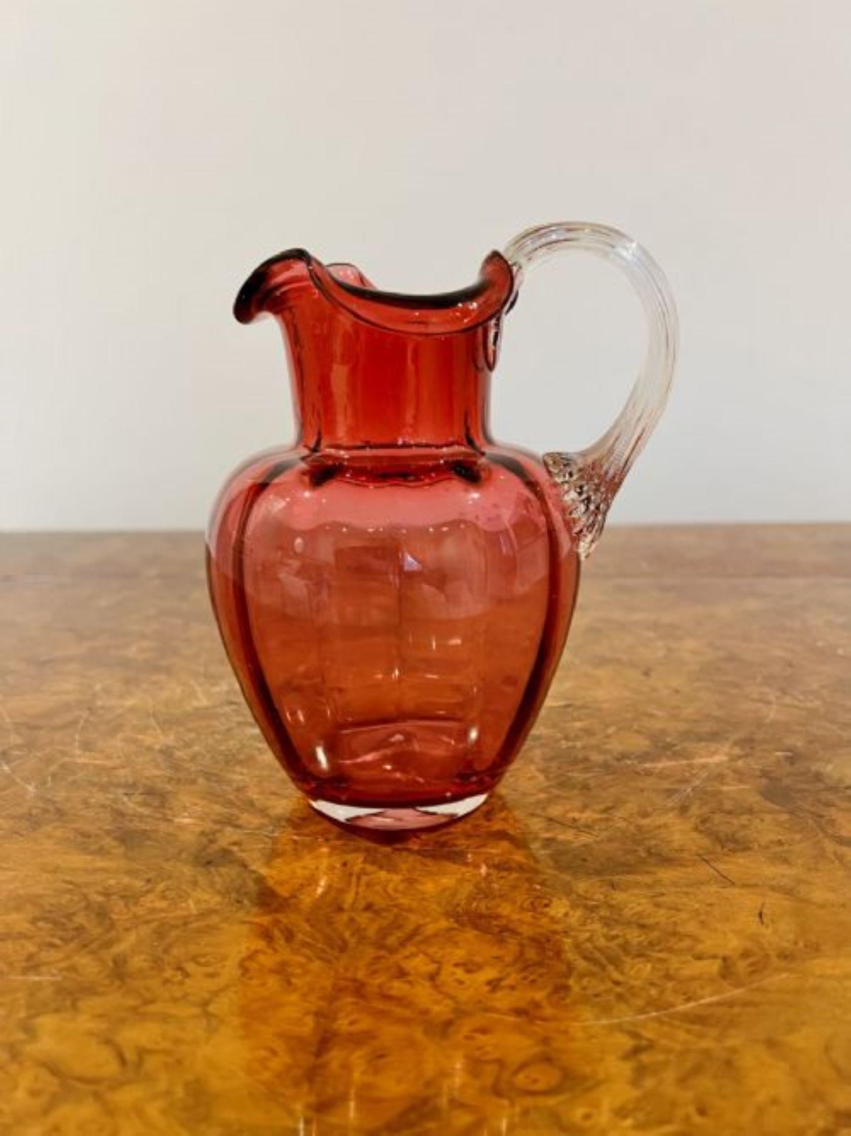 Antique Victorian cranberry glass jug having an original quality cranberry glass jug with a shaped handle 