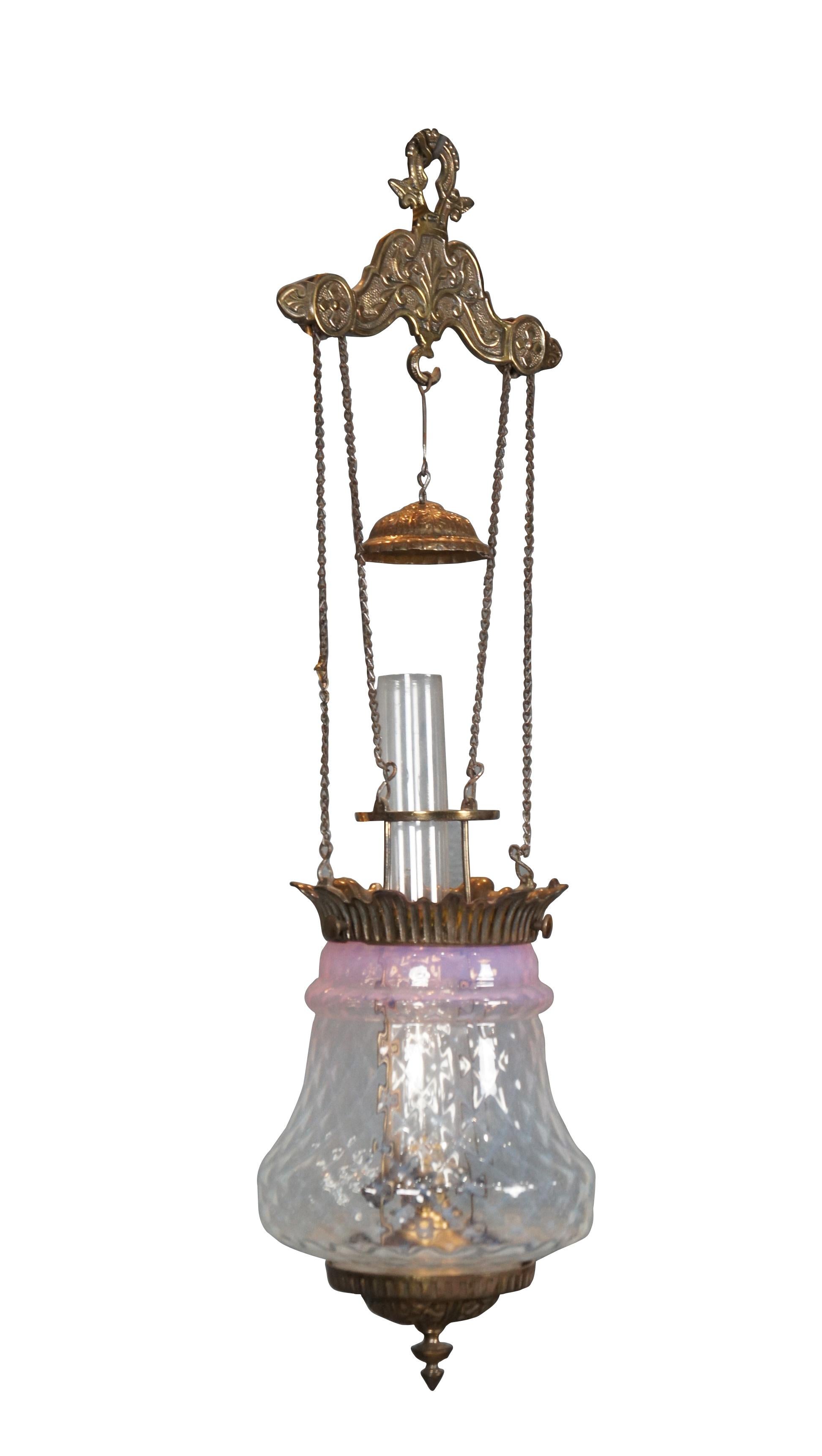 Late 19th century converted oil swag hurricane pendant light / chandelier. Repousse brass base with finial and matching smoke bell; pineapple shaped opalescent glass shade with cranberry blush at top and rim of brass leaves. Suspends from floral