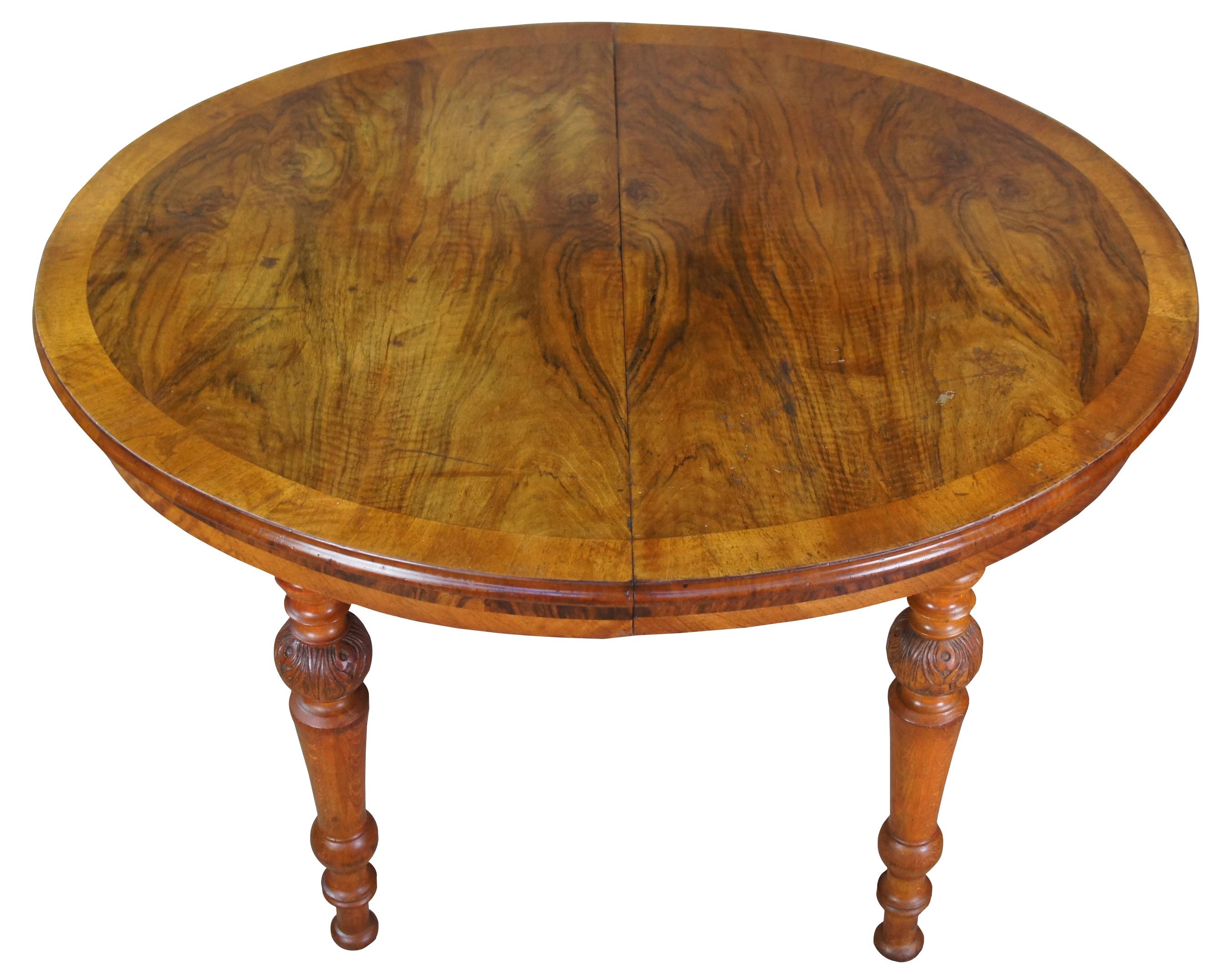 Antique Victorian dining or breakfast table. Made of Crotch Walnut featuring ovular or rounded form with circular banding and carved turn legs with castors. Measure: 48