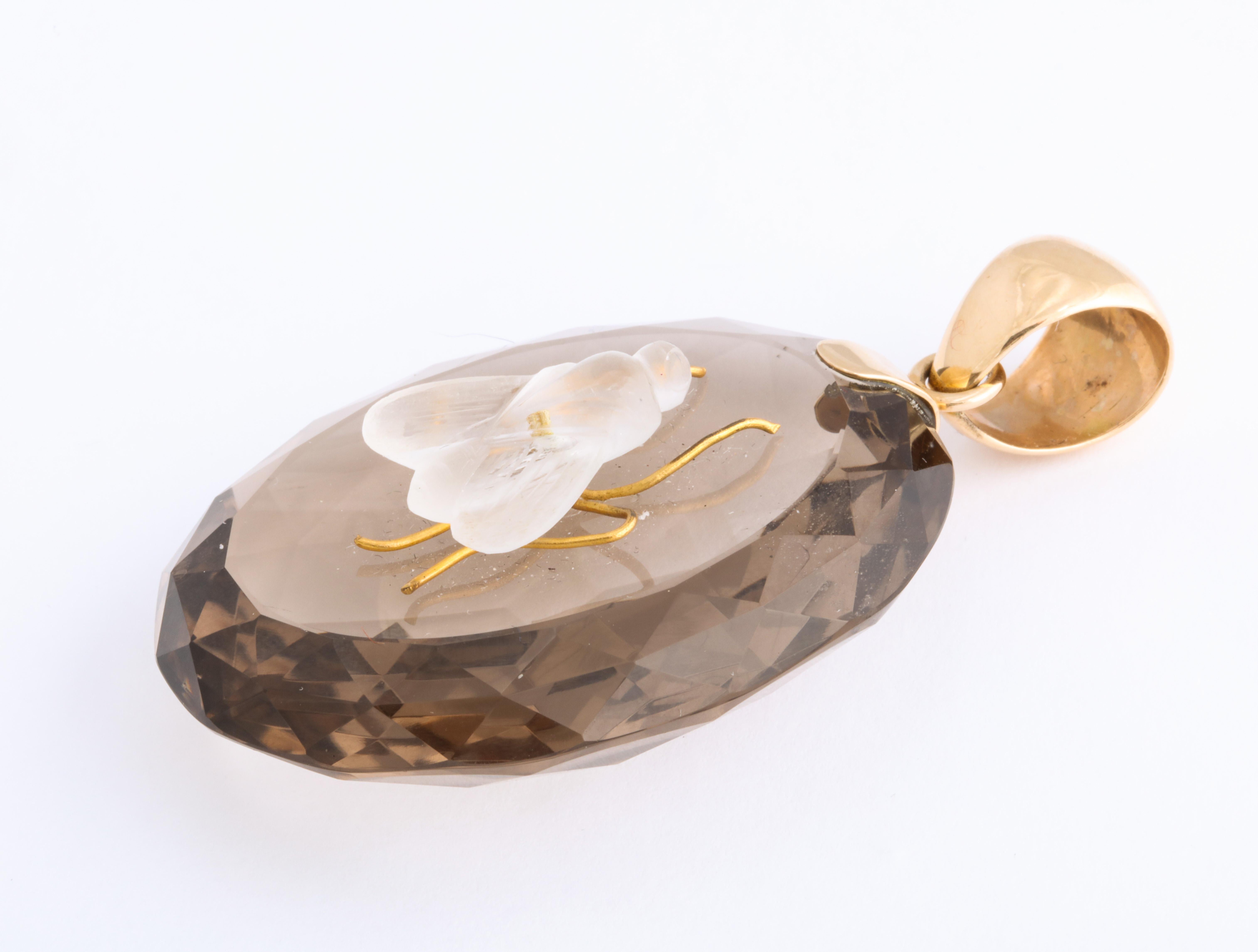 What is all the buzz about. It is the allure of this unique, clear smoky crystalline quartz on which sits a three dimensional rock crystal fly, complete in detail with engraved wings and gold antennae. I cannot stop admiring it, its faceted edges