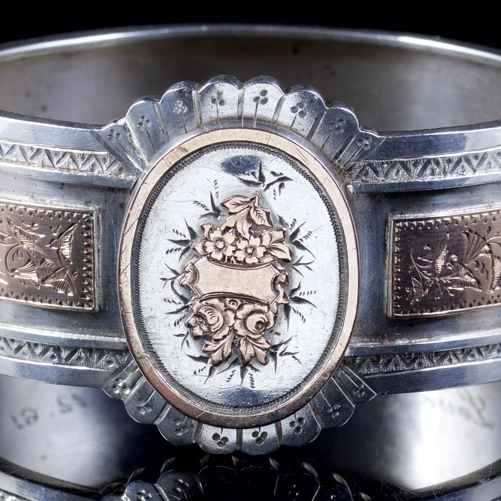 This spectacular Victorian Silver cuff bangle is, Circa 1880.

The beautiful bangle is inlaid with Rose Gold floral details around the front of the bangle.

The Oval centre boasts embossed Rose Gold ‘Forget me Nots’ with a Rose Gold outer