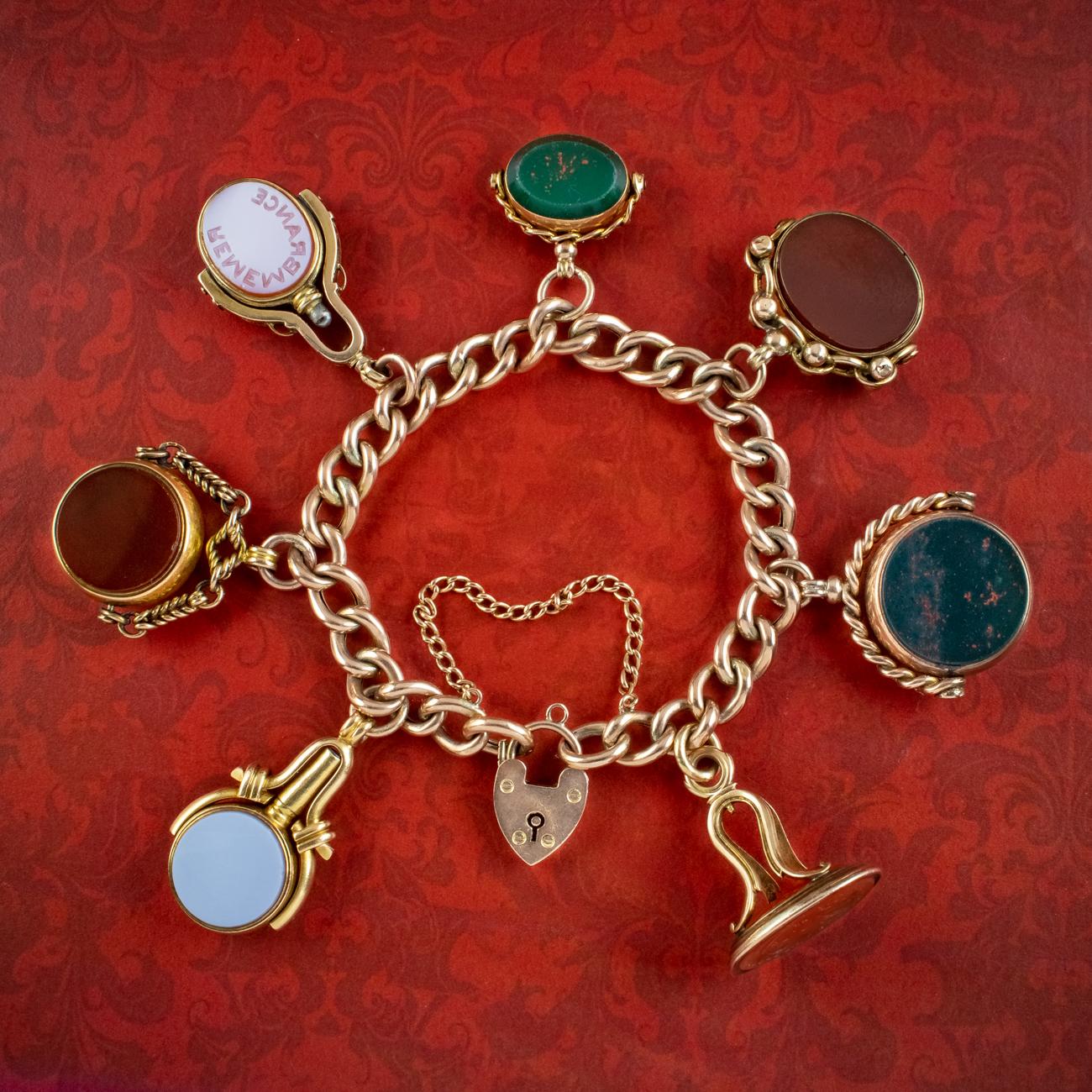 A remarkable antique Victorian 9ct gold curb bracelet from the late 19th Century featuring seven unique fobs, two of which are in the form of watch keys. Each fob can be rotated and is set with bloodstone, carnelian and white agate seals on both