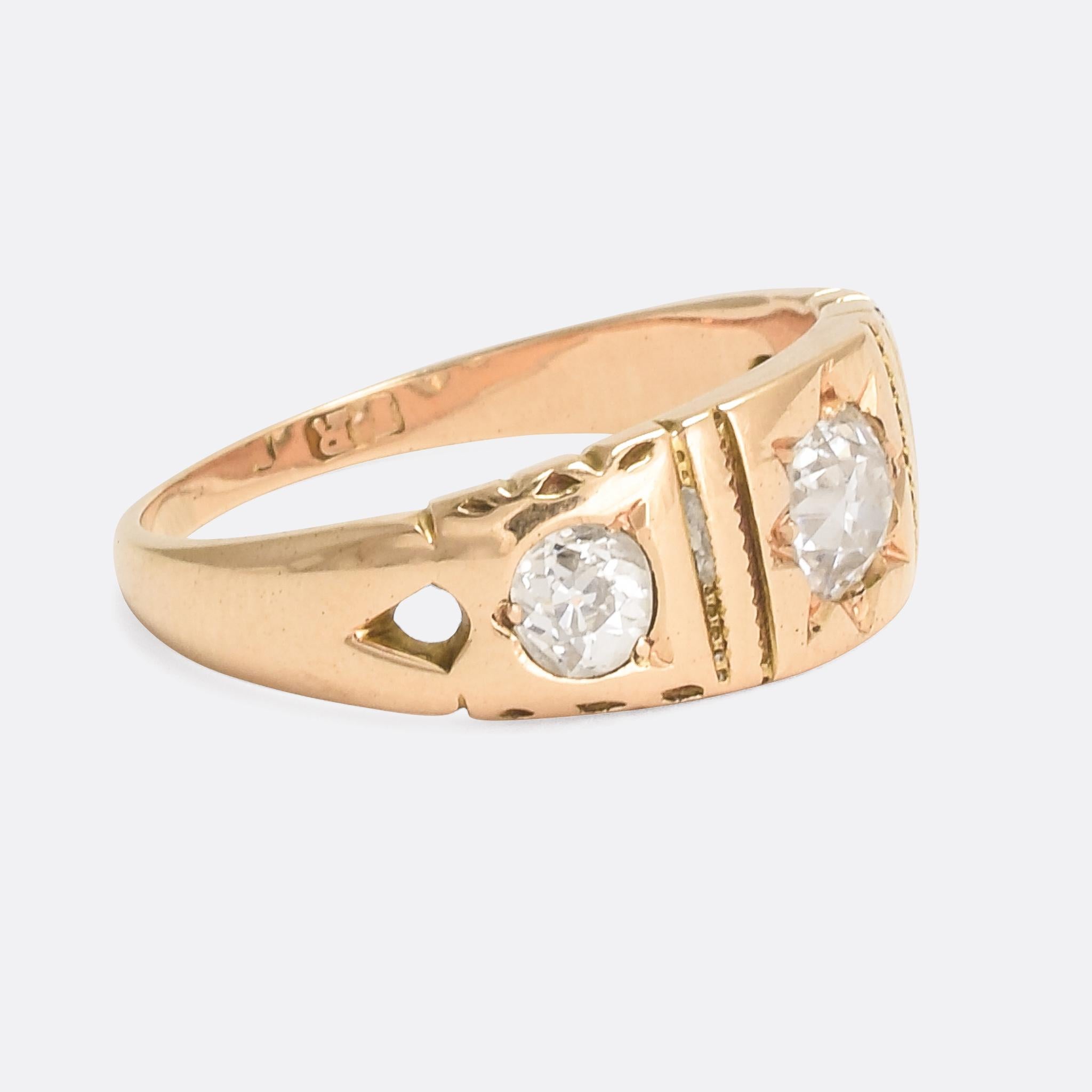 An elegant late Victorian three-stone band set with bright antique cushion cut diamonds. The detailing and craftsmanship are both excellent, with star-settings and subtly openworked shoulders. It's modelled in 18 karat yellow gold and dates from