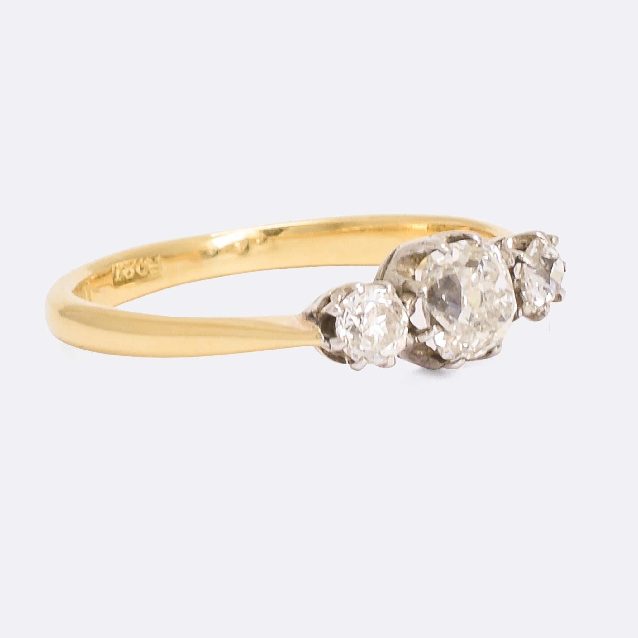 A beautiful antique trilogy ring set with cushion cut diamonds. It dates from the late 19th Century, circa 1900; home to a total of .75cts of diamonds in platinum claw mounts. The band is 18 karat yellow gold, that creates a lovely contrast with the