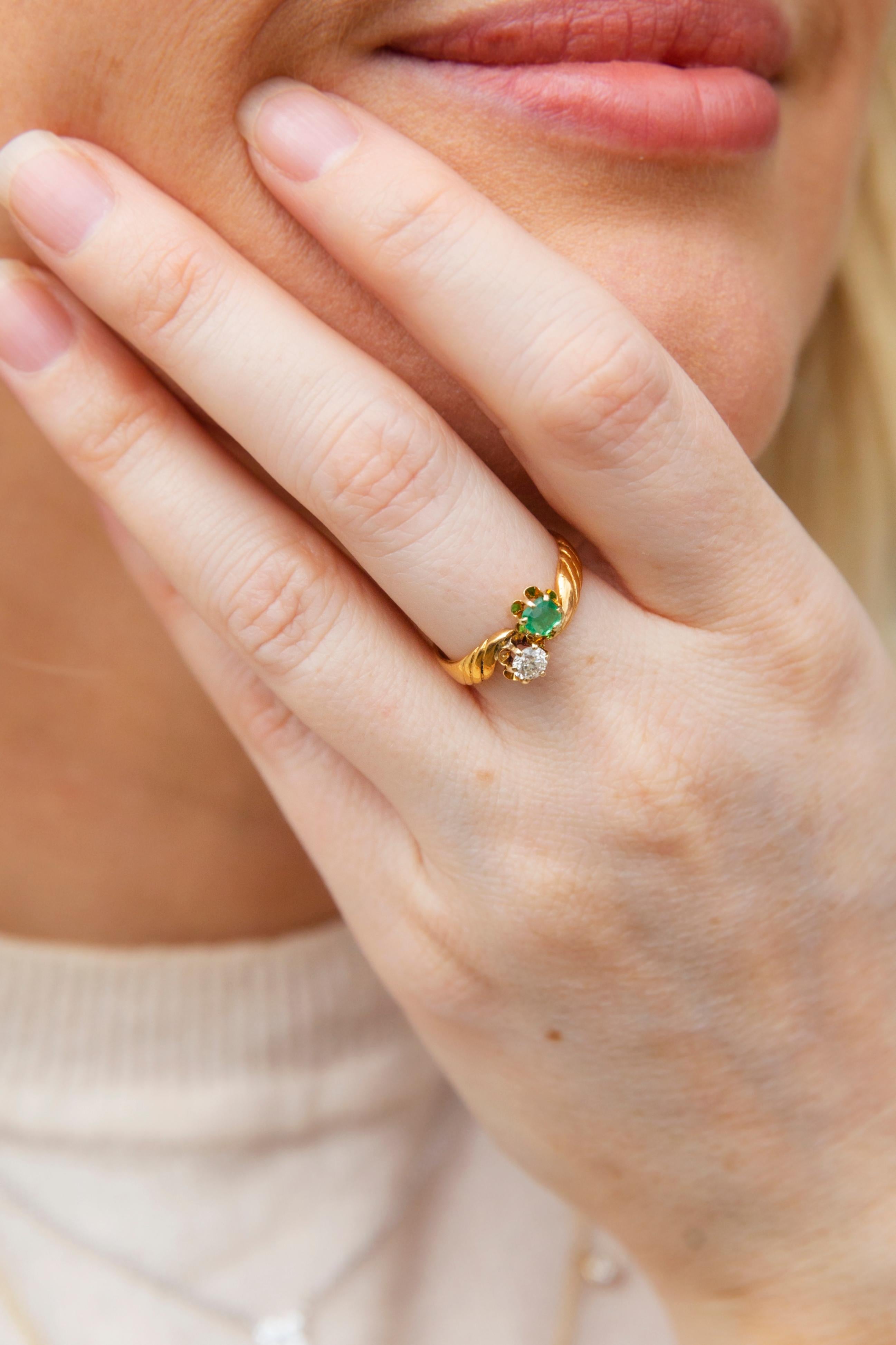 Der aus 18 Karat Gold gefertigte Ring Arlene ist eine wahre Freude im Vintage-Stil. Ihr leuchtend grüner Smaragd und ihr funkelnder Diamant liegen in Blumenkörben über einem goldenen Band, das sich um sie windet. Eine perfekte Ergänzung für jede