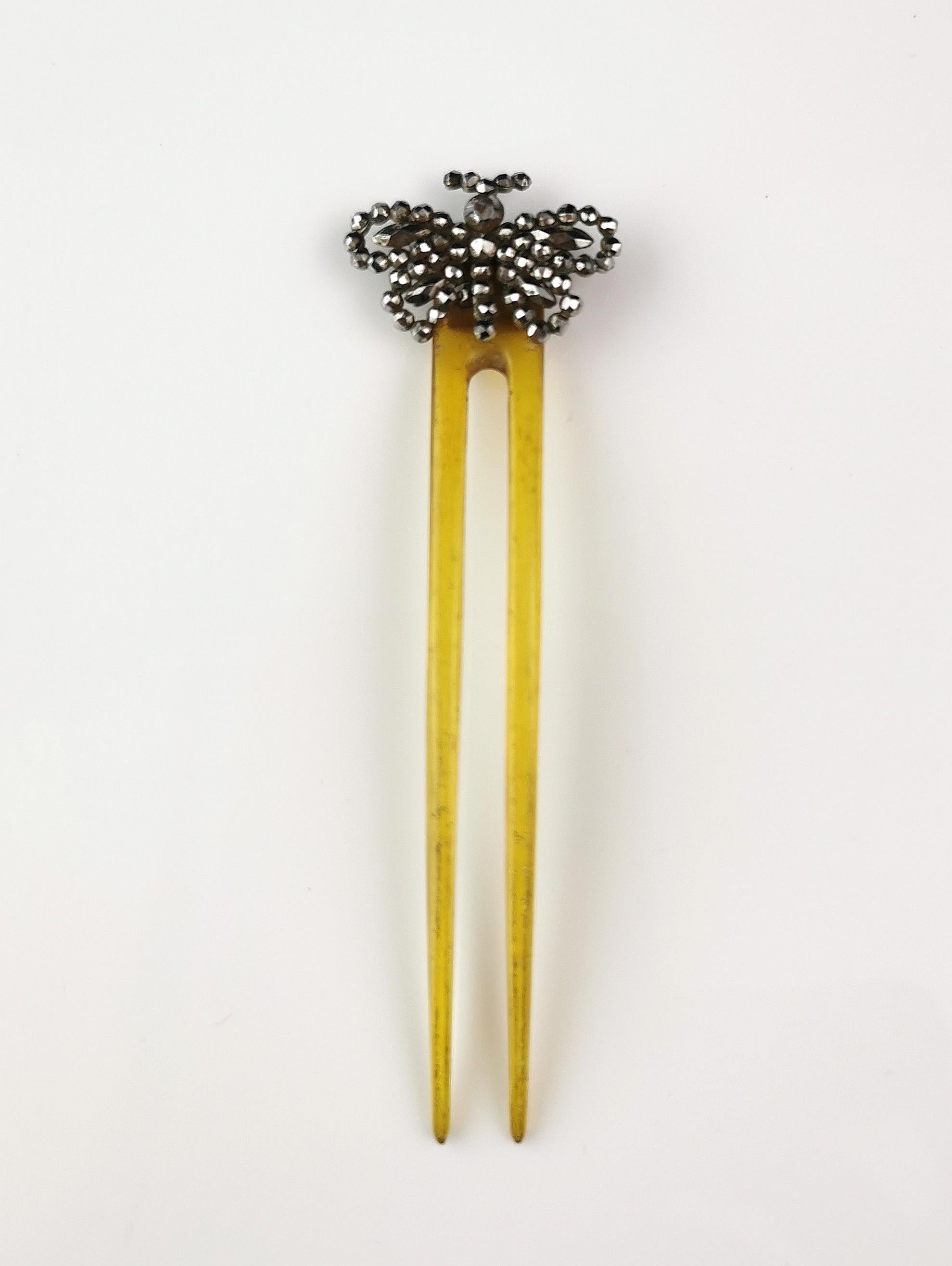 A gorgeous antique Victorian era hair comb.

It is a two pronged celluloid hair comb in a yellow shade.

The top is adorned with a pretty cut steel butterfly.

Cut steel was popularised in the 18th century, painstakingly hand cut and polished steel