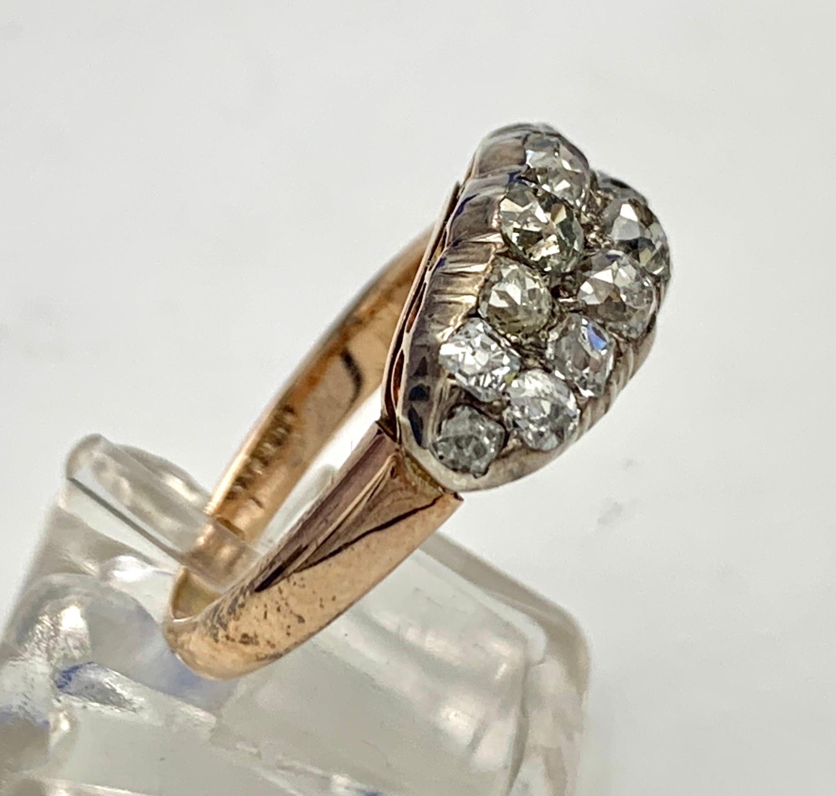 This solid Victorian cluster ring is decorated with 14 old mine old cut diamonds set in silver. The ring is made out of 18 karat red gold and marked 18ct.