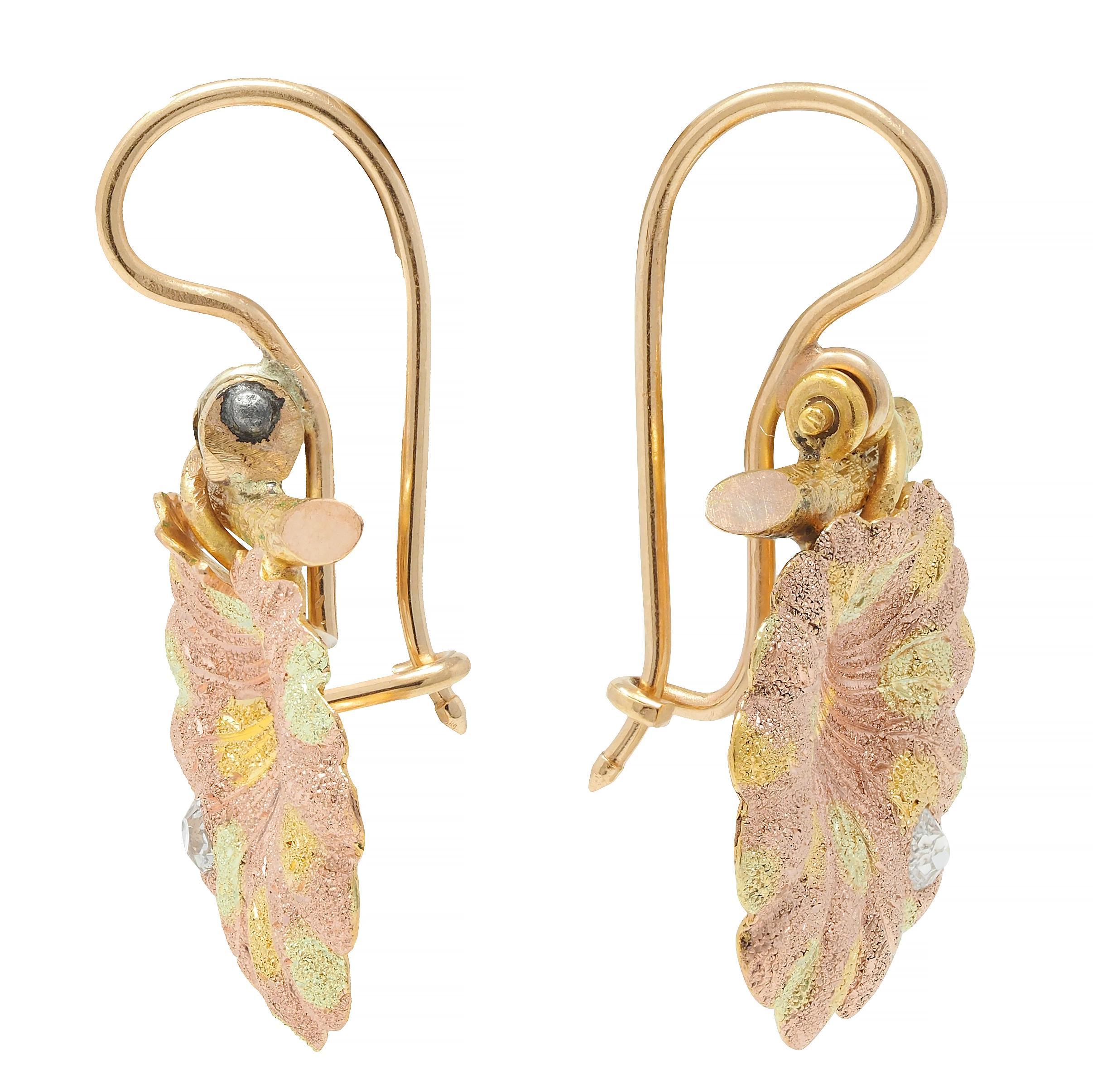Designed as rose gold geranium leaf drops with dimensional organic form
Accented by yellow and green gold spots - textured throughout
With engraved veining and stem wrapping around branch
Flush set with old mine cut diamonds at bottom
Weighing