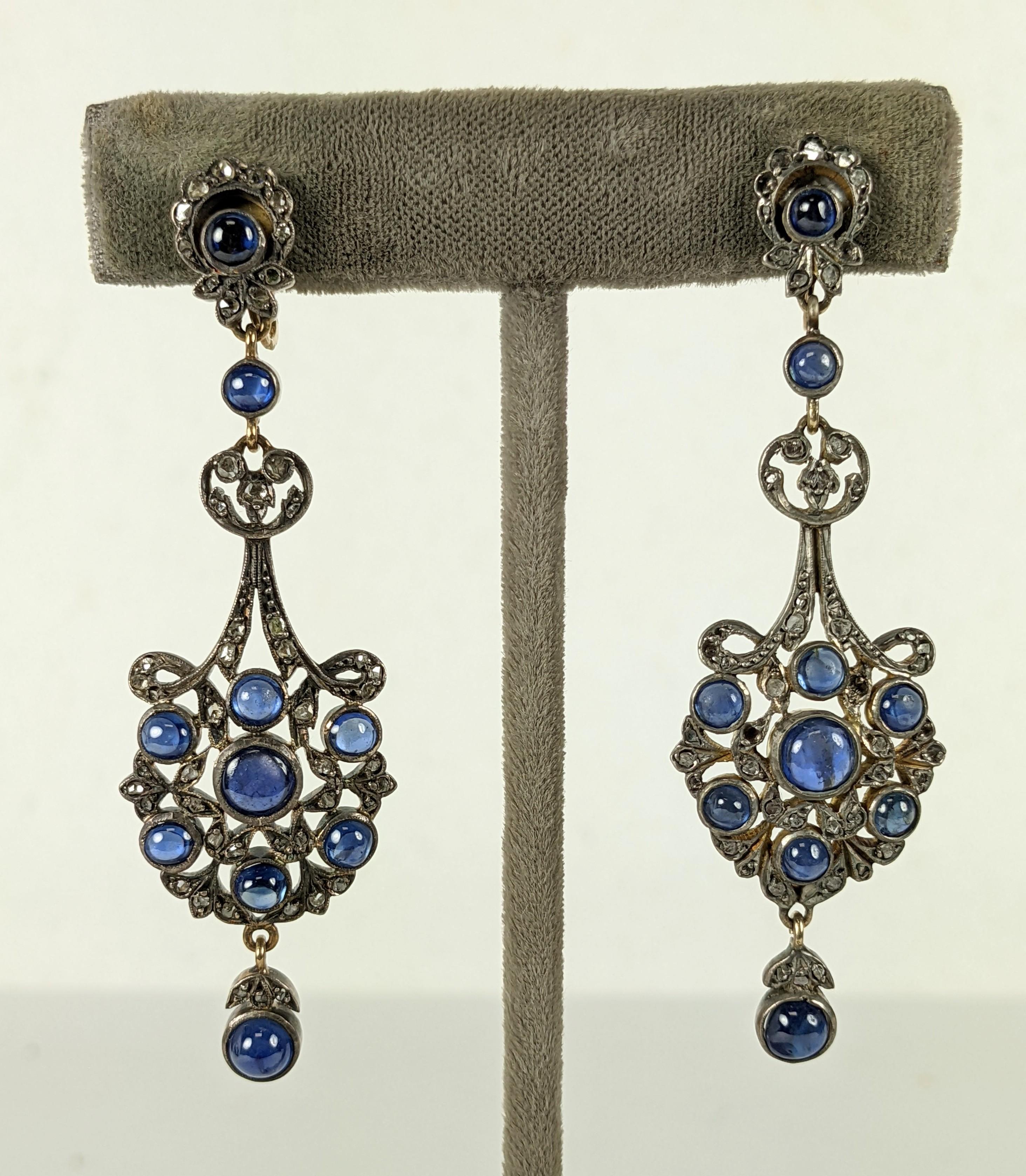 Elegant Antique Victorian Diamond and Sapphire Drop Earrings from the late 19th Century of silver topped gold. Lovely blue cabochon sapphires set in gold bezels in an openwork silver Art Nouveau pattern set with rose diamond chips. Screw back