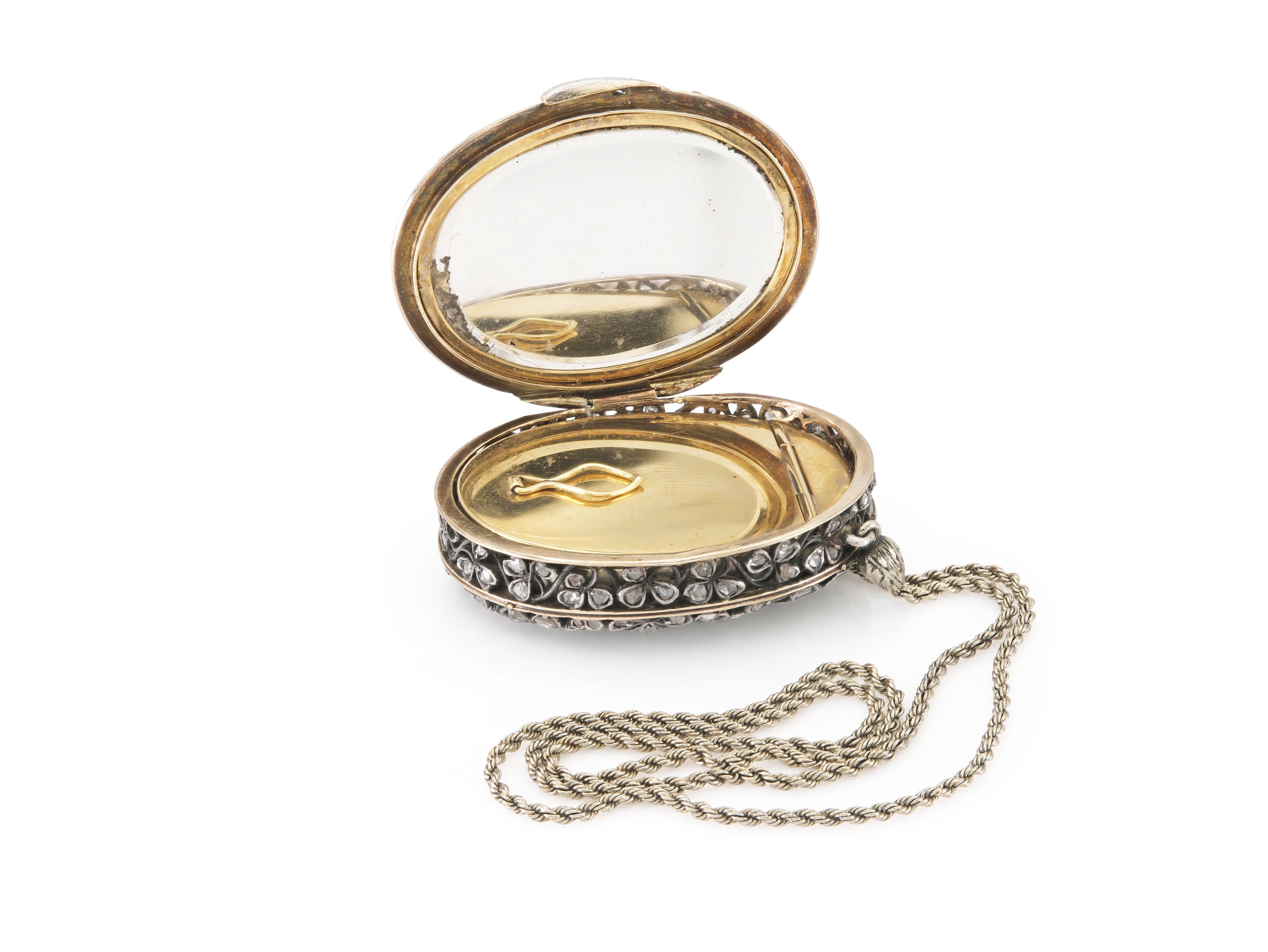 Finamente elaborada en plata sobre oro amarillo de 18 quilates y diamantes talla rosa con un espejo en el interior.
Hacia finales de 1800
1 3/8 x 1 pulgada + cadena de 12 pulgadas