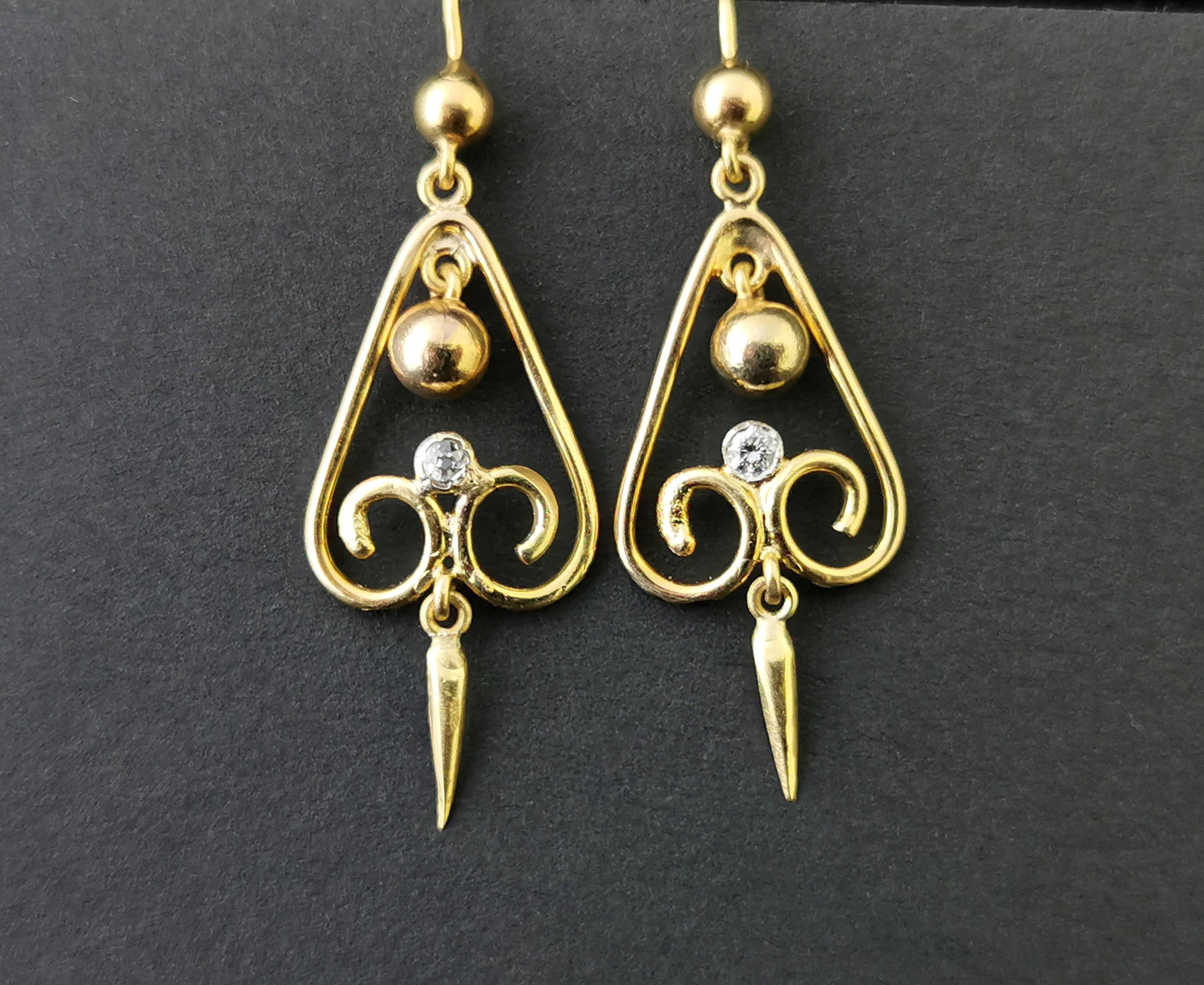 A truly stunning pair of antique, Victorian era, 15 karat yellow gold and diamond drop earrings.

Beautiful, bright and vibrant gold scrolling drops in a teardrop shape with a large articulated gold bead to the top centre.

At the base of each