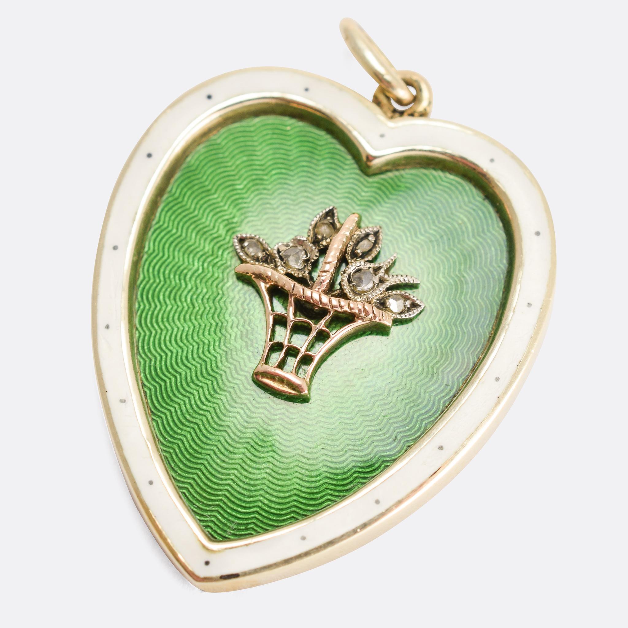 A stunning antique heart pendant dating from the turn of the 20th Century. Set with a diamond flower basket to the centre, within a sea of beautiful green guilloché enamel, and finished with a white enamel border. The craftsmanship is excellent