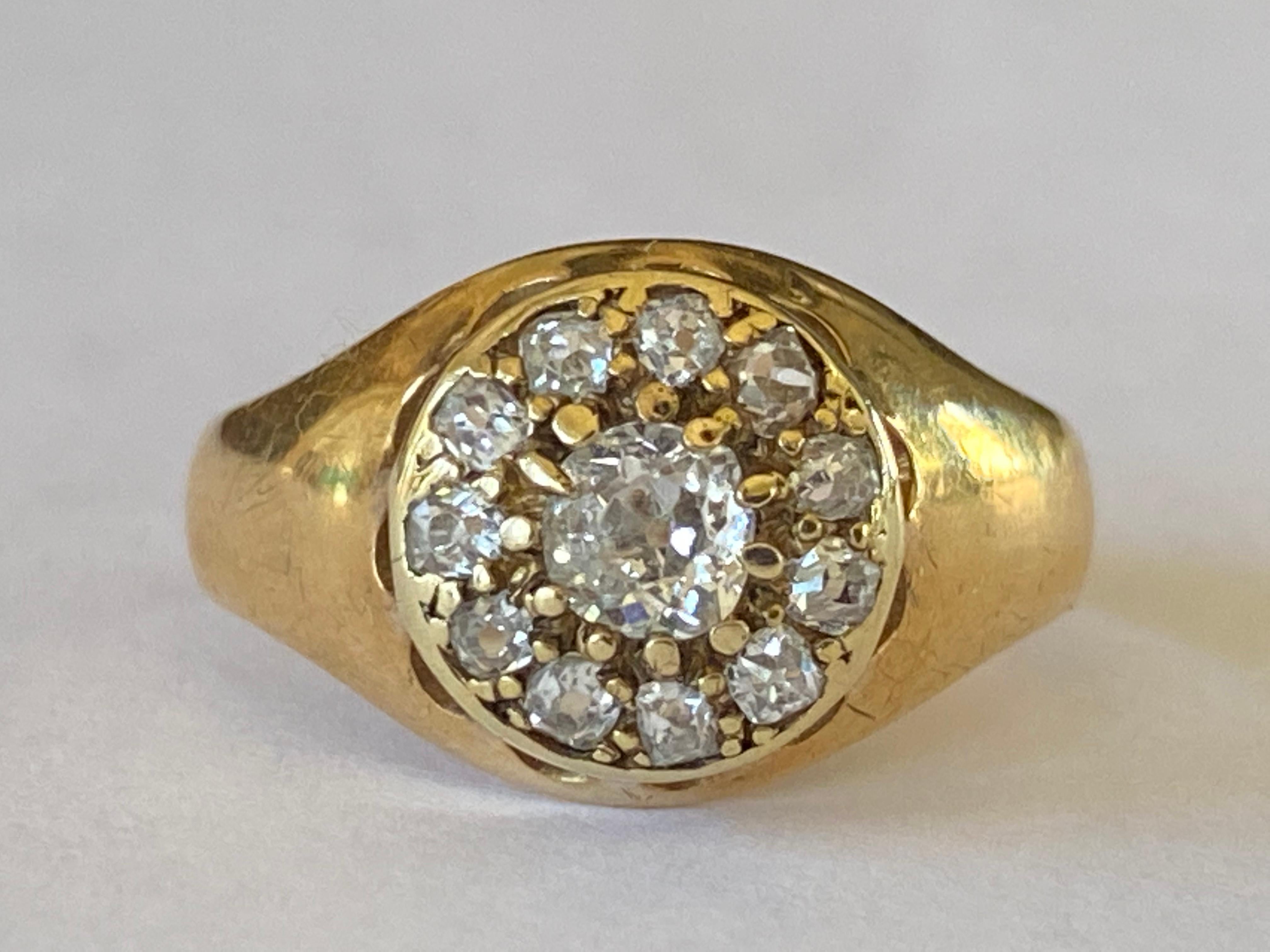 This antique Victorian cluster ring is designed around an Old Mine cut diamond center stone measuring approximately 0.30 carats, H color, VS clarity encircled by a halo of eleven smaller Old Mine diamonds totaling approximately 0.55 carats and