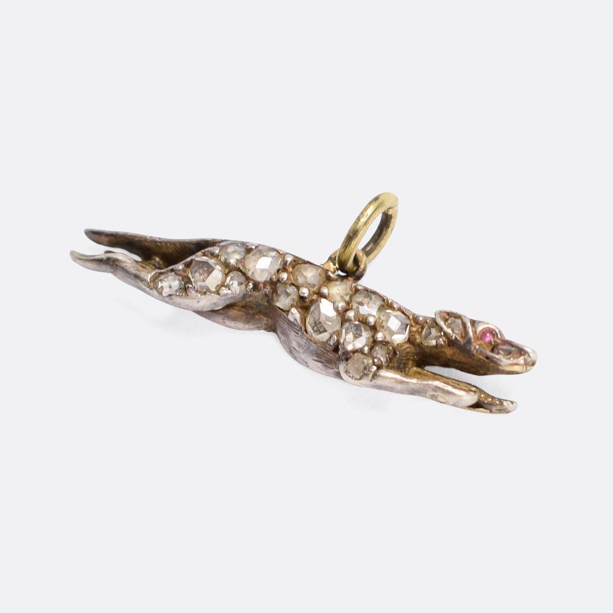 A wonderful antique greyhound pendant, set with rose cut diamonds and ruby eyes. The dog is running at full tilt, masterfully captured in motion. Modelled in 9k gold with silver settings, it dates from c.1890.

STONES
Rose cut