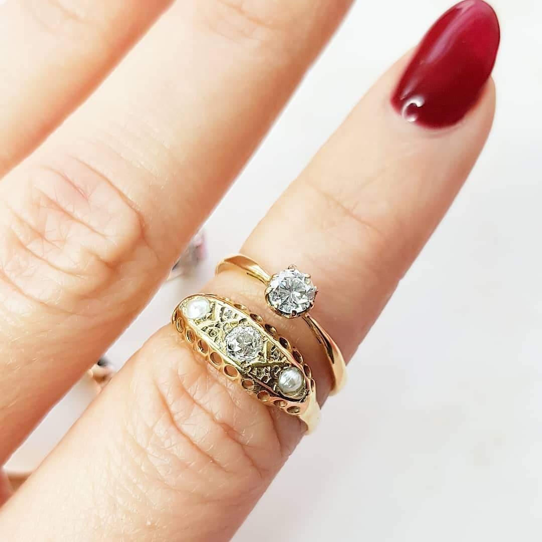 Antique Victorian ring featuring an Old European Cut diamond ring alongside two pearls. The ring is set in an 18ct yellow gold setting. the diamond is approximately 0.11ct. 

This style of the ring would have been an engagement ring, giving diamonds