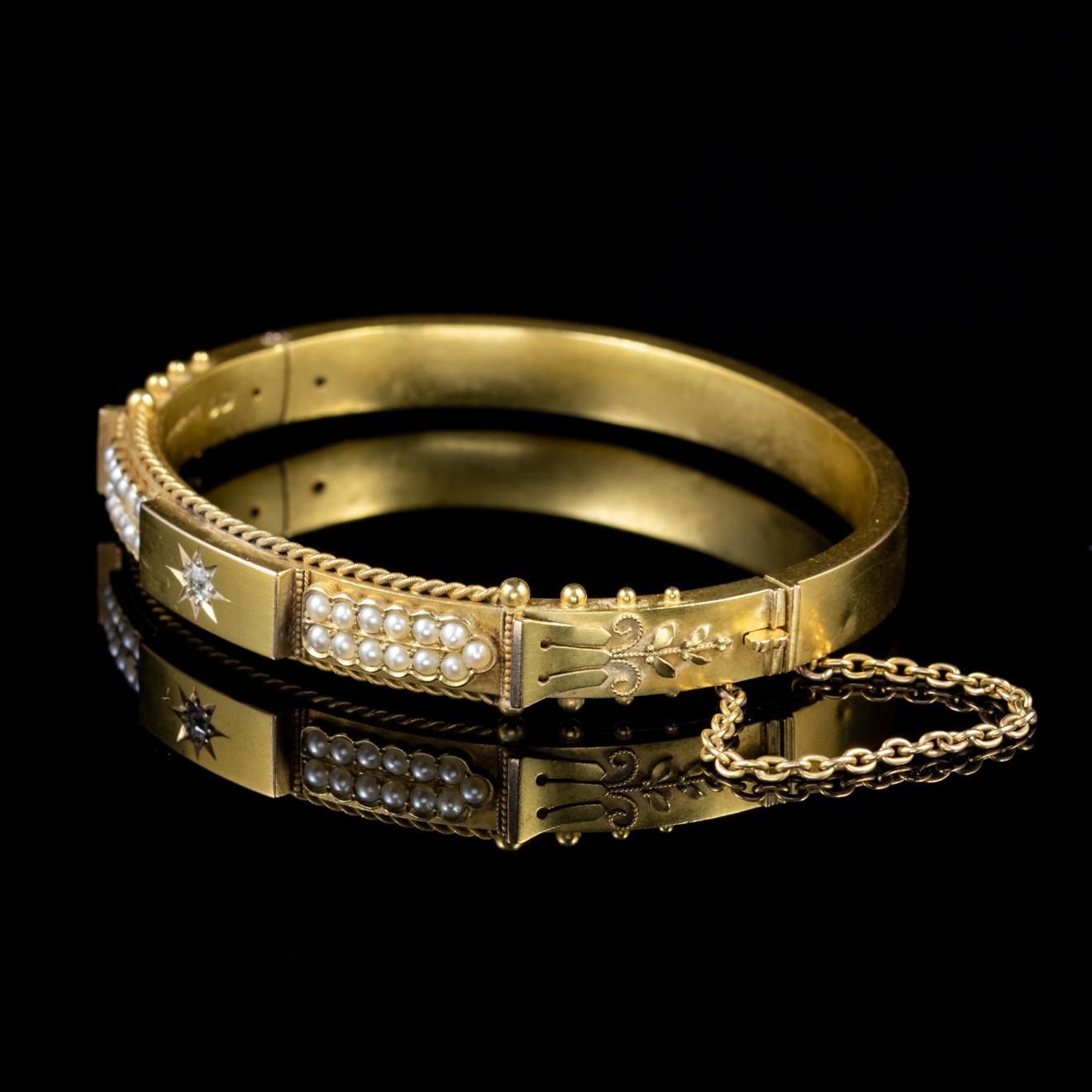 A wonderful antique Victorian bangle with a striking front gallery decorated with four lines of Pearls joining in the centre to meet a star set Diamond. 

The bangle displays fine detail with a rope twist edging and Etruscan sides. Fashioned in