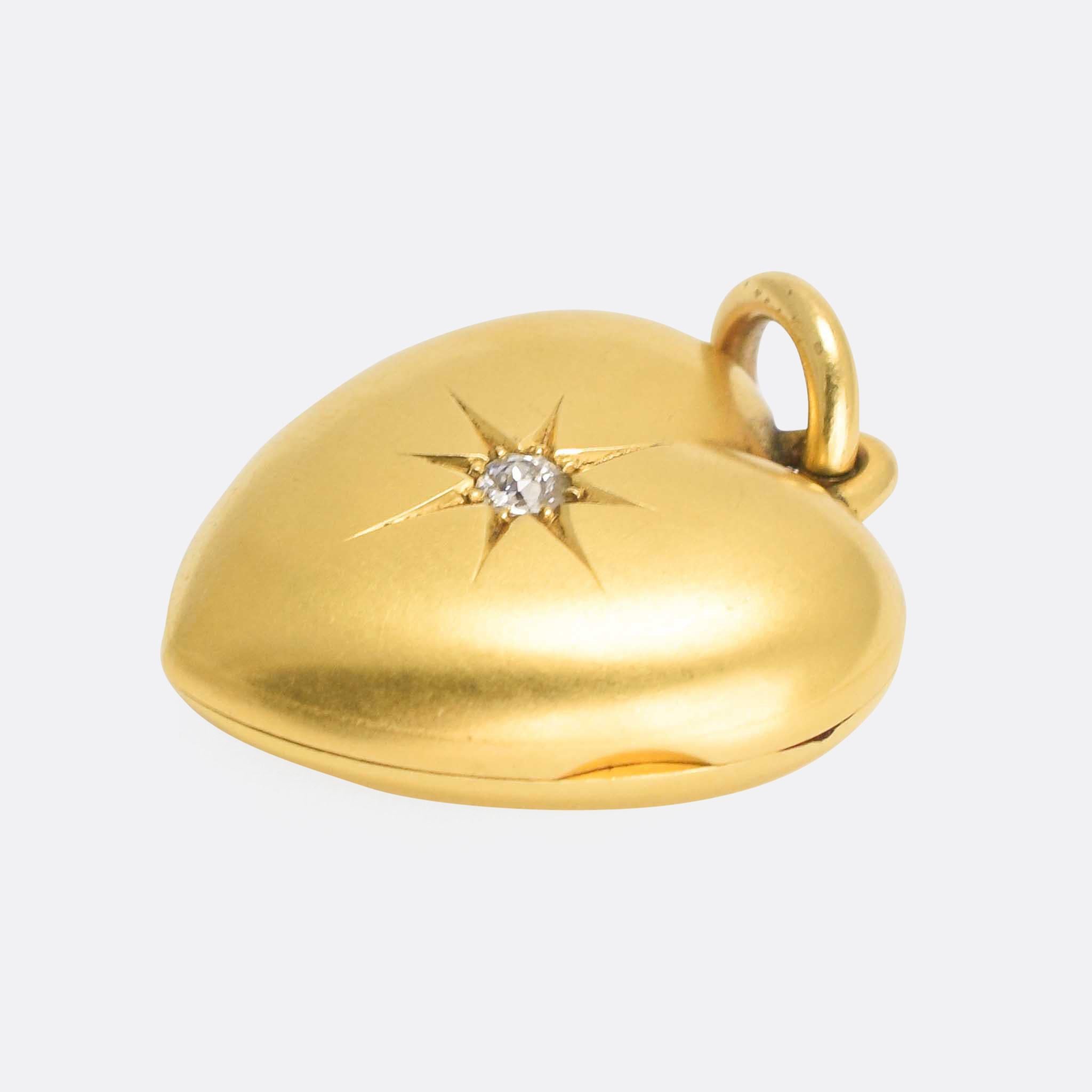 A beautiful antique heart locket pendant with an old cut diamond in a stylised star setting. The 15 karat gold has a lovely matte finish, and the piece opens to reveal an inner locket compartment. It dates from the latter half of the 19th Century,